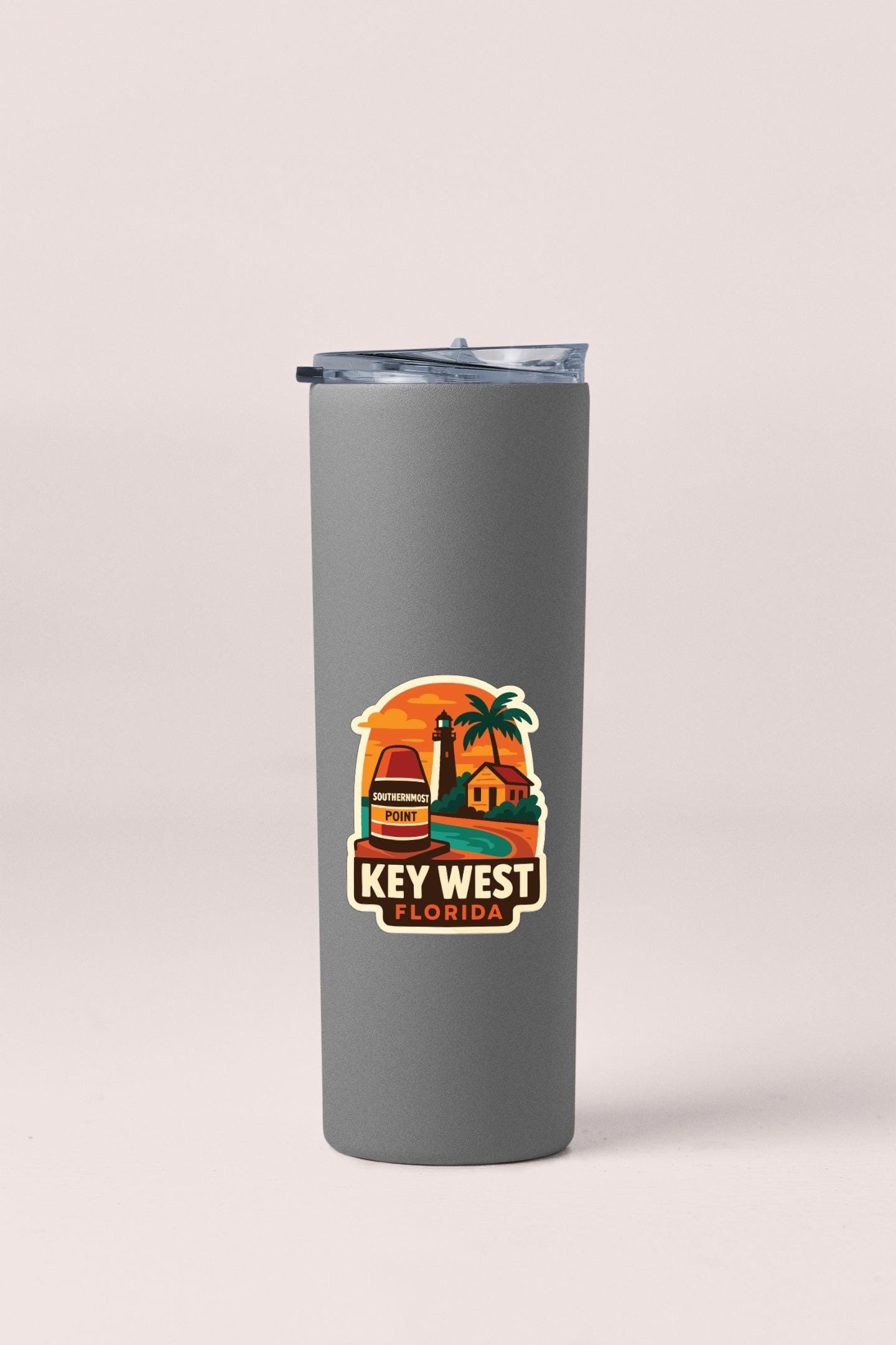 A gray insulated tumbler with a sticker depicting a tropical beach scene and the text "KEY WEST FLORIDA".