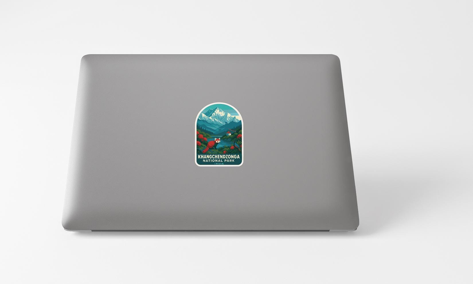 A sticker with a mountain landscape and text on the back of a laptop computer.
