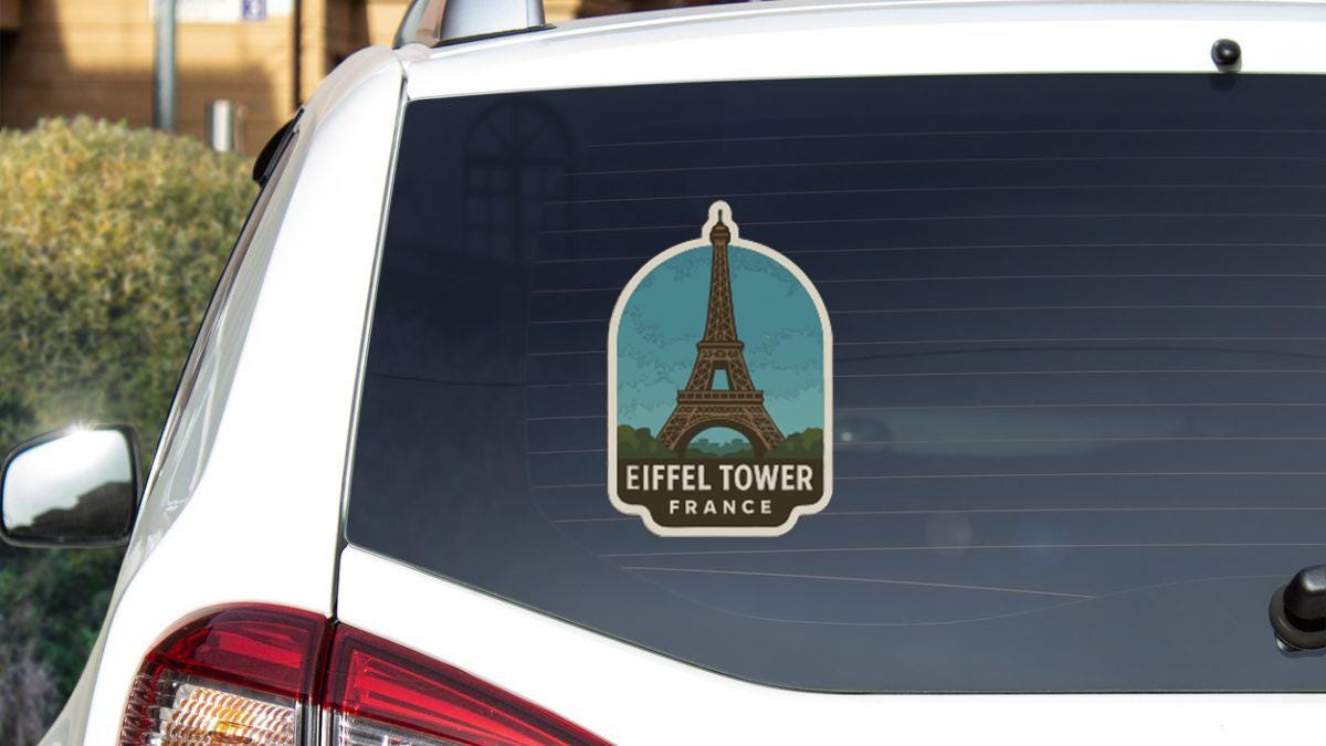 a sticker on the rear window of a white car that says "Eiffel Tower France".