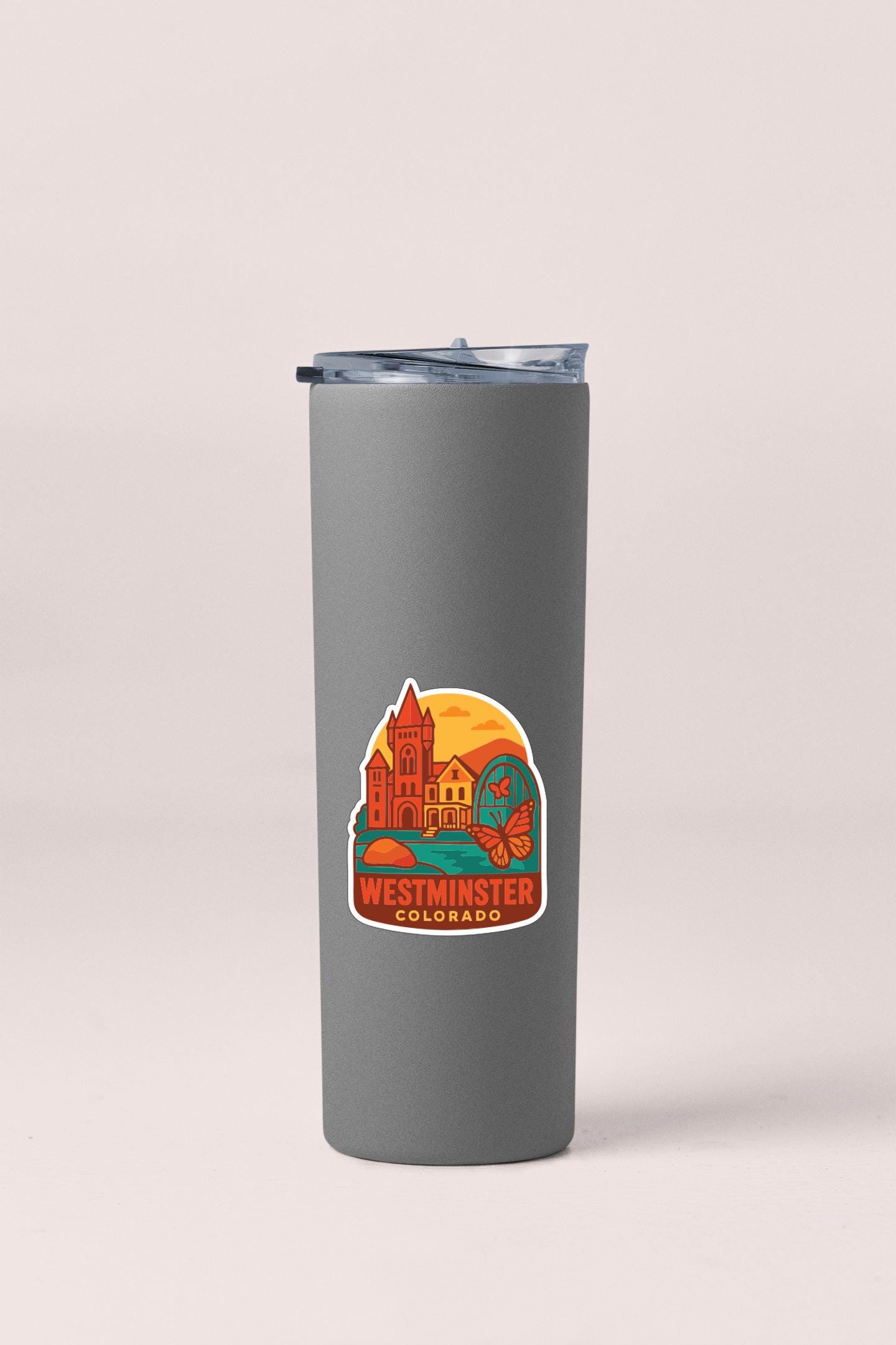 A gray insulated tumbler with a sticker depicting Westminster, Colorado.