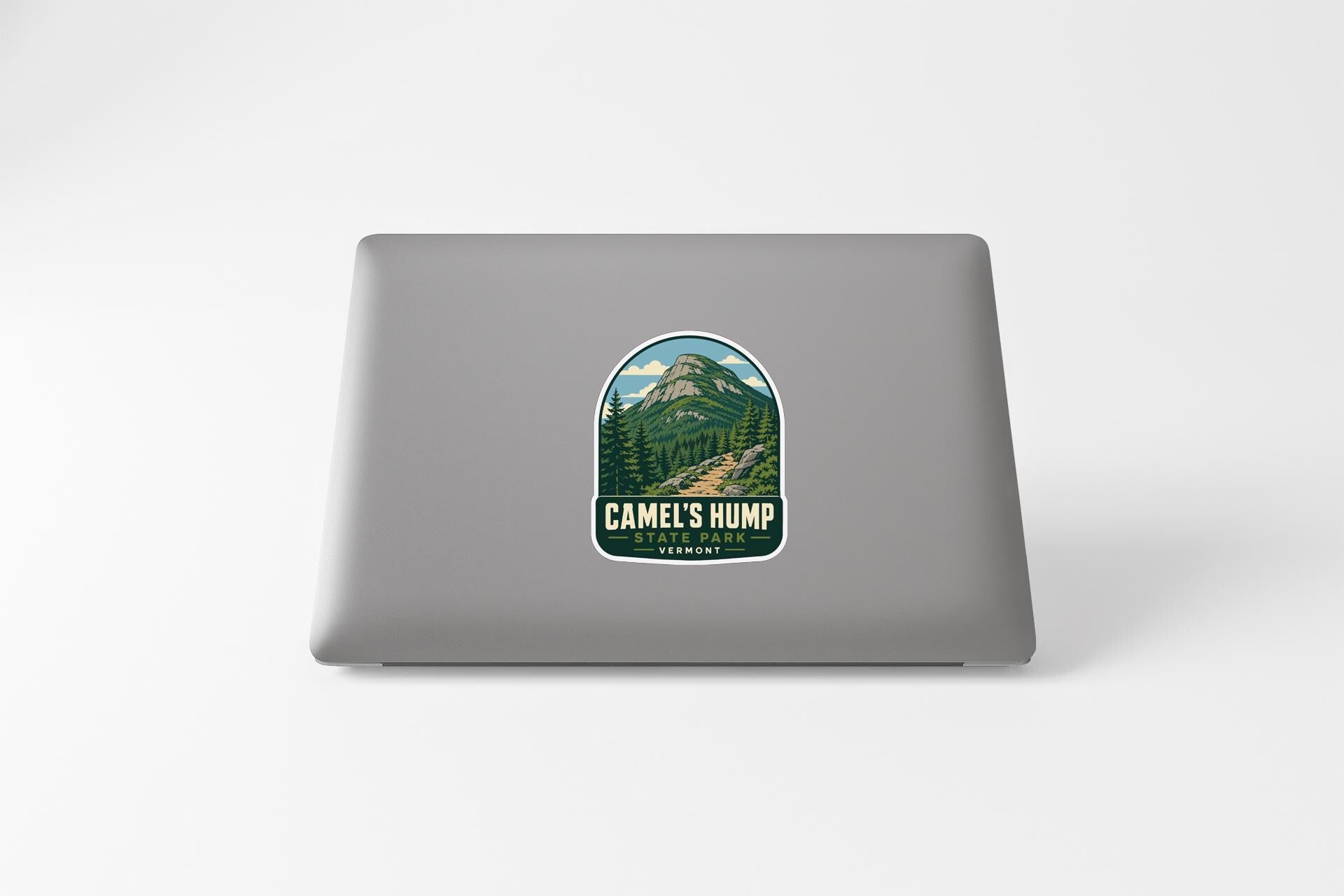 a sticker with a mountain landscape and the text "CAMEL'S HUMP" on the back of a laptop.