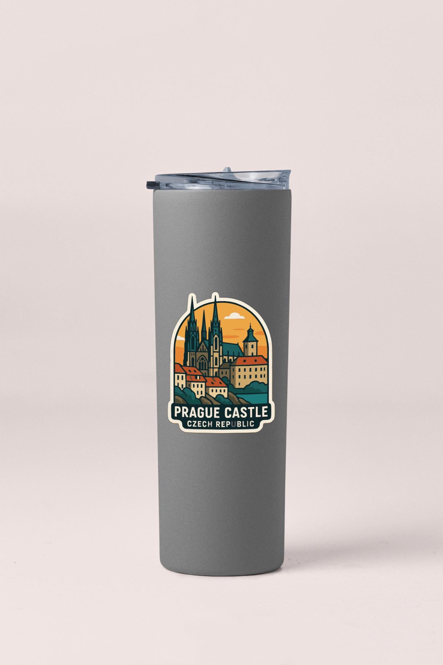 A gray insulated tumbler with a printed sticker depicting the Prague Castle in the Czech Republic.