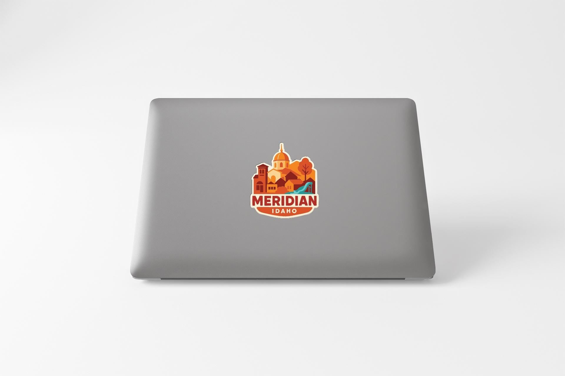 a sticker with a logo of a city and the text "MERIDIAN IDAHO" on the back of a laptop.