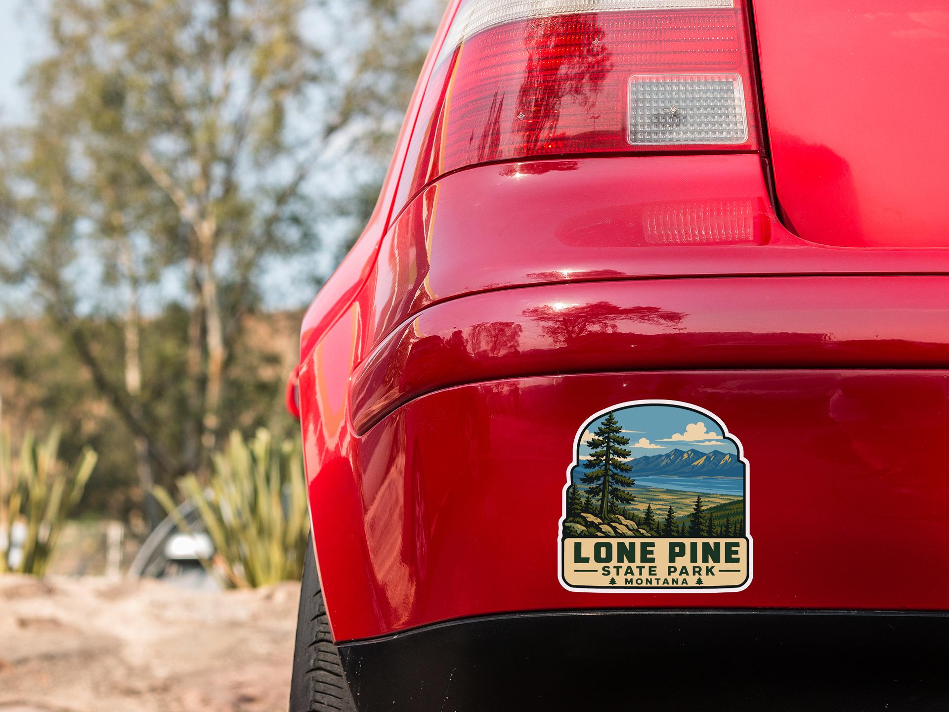 the rear end of a red car with a sticker on the back window that says "Lone Pine State Park".