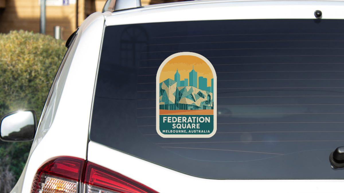 a sticker on the rear window of a white car, featuring an illustration of Melbourne, Australia.