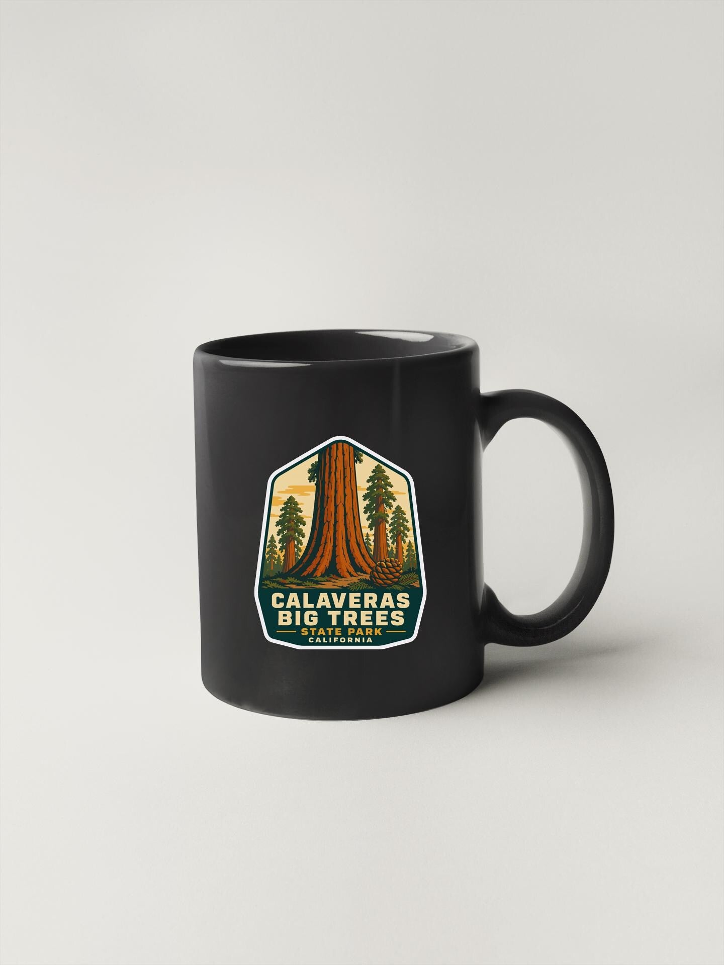 a black coffee mug with a picture of a tree