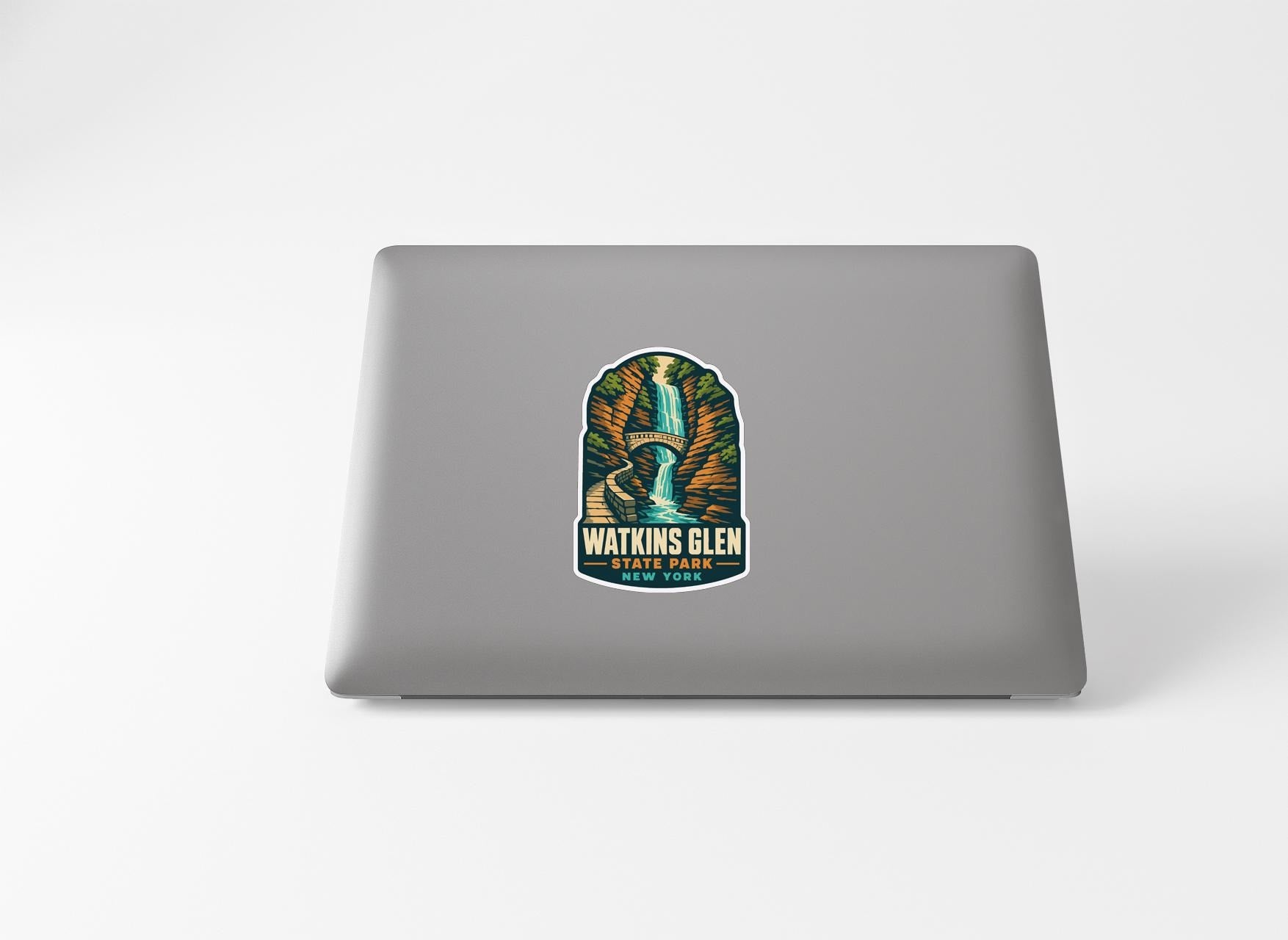 A sticker with a waterfall and the text "WATKINS GLEN STATE PARK" printed on a laptop.