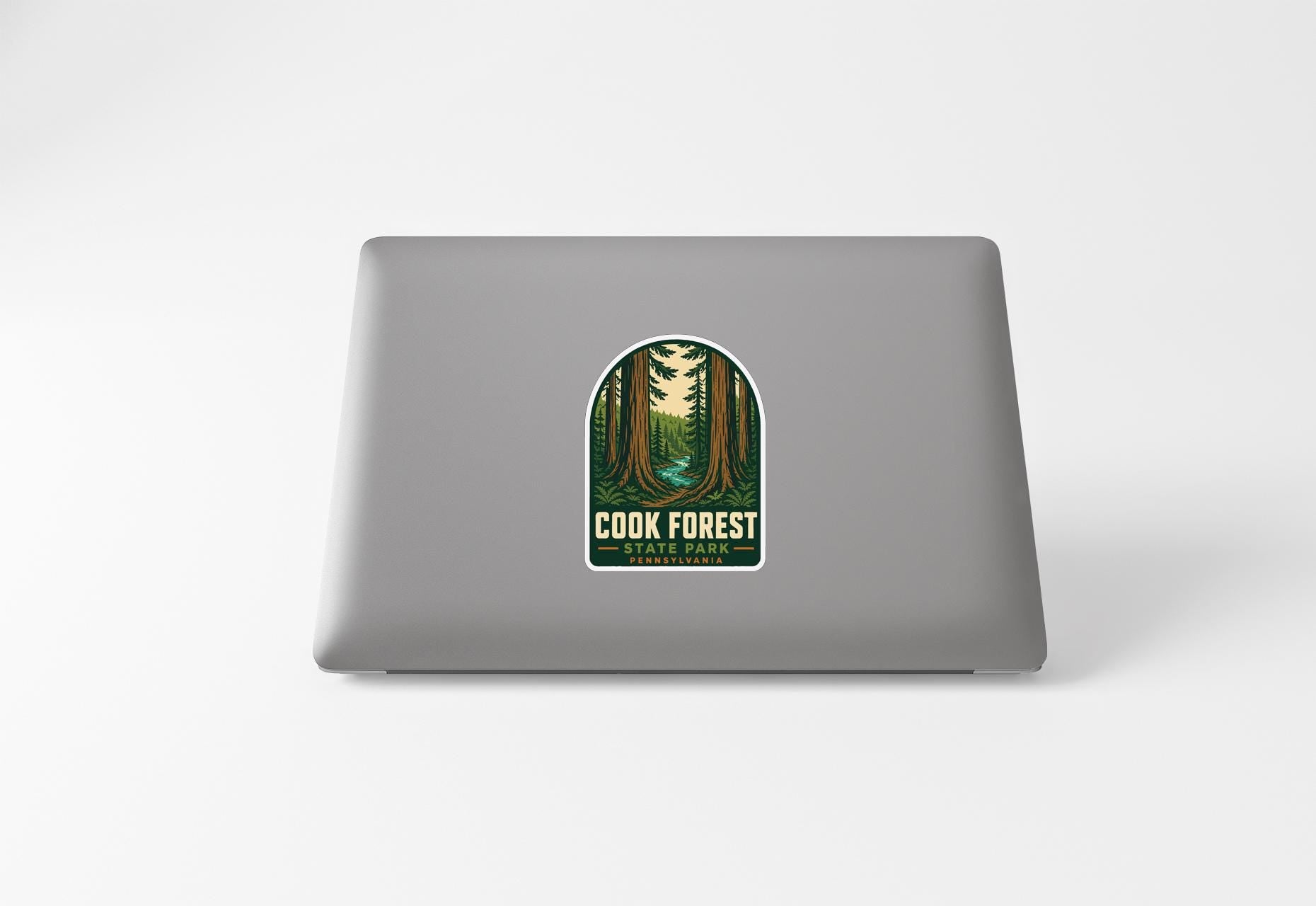 a sticker with a forest scene on a laptop.