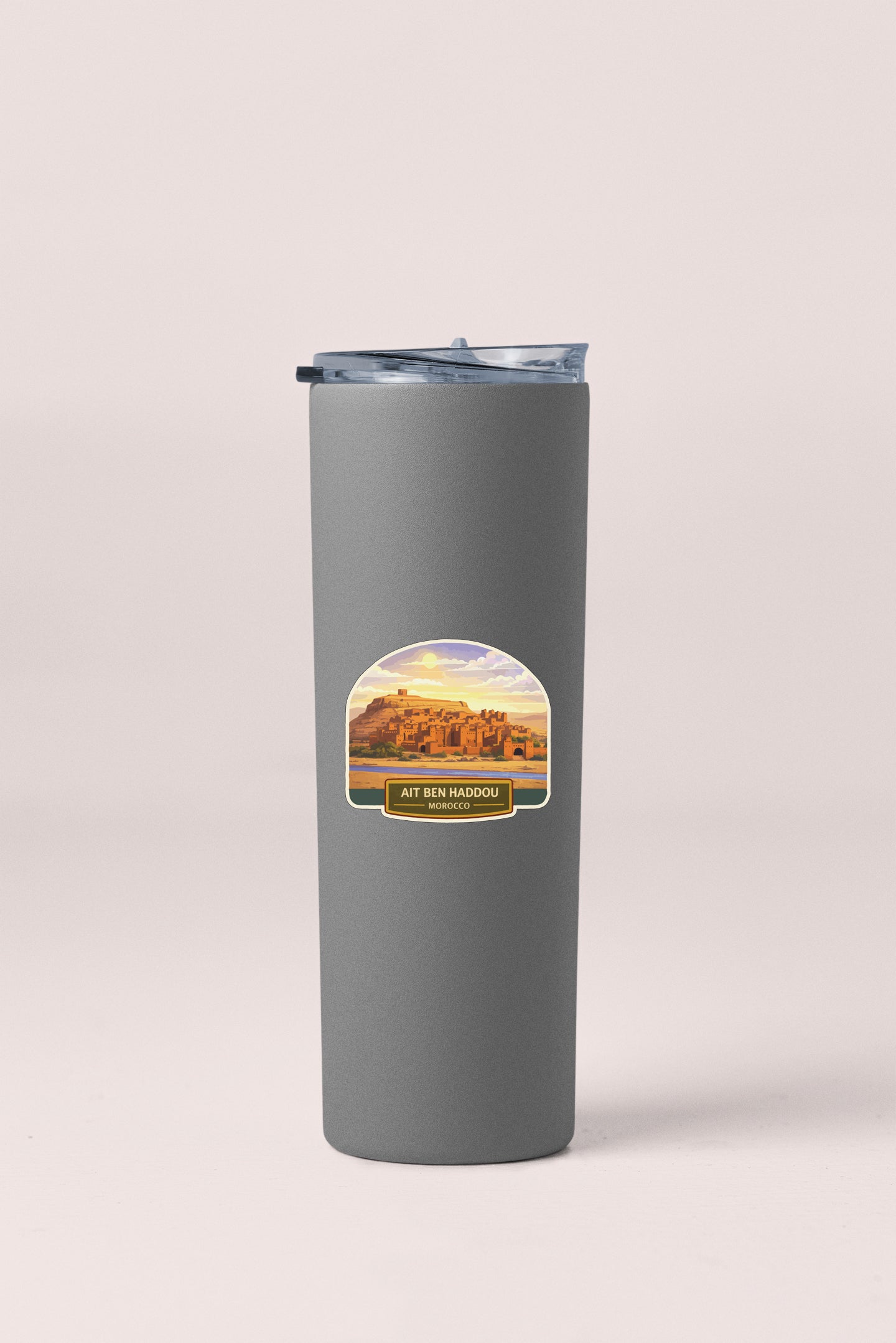 A gray insulated tumbler with a lid and a label featuring a desert landscape.