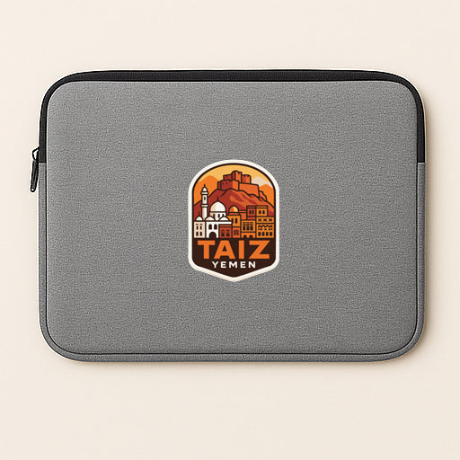 A gray laptop sleeve with a graphic design featuring a cityscape and the text "TAIZ YEMEN" printed on it.