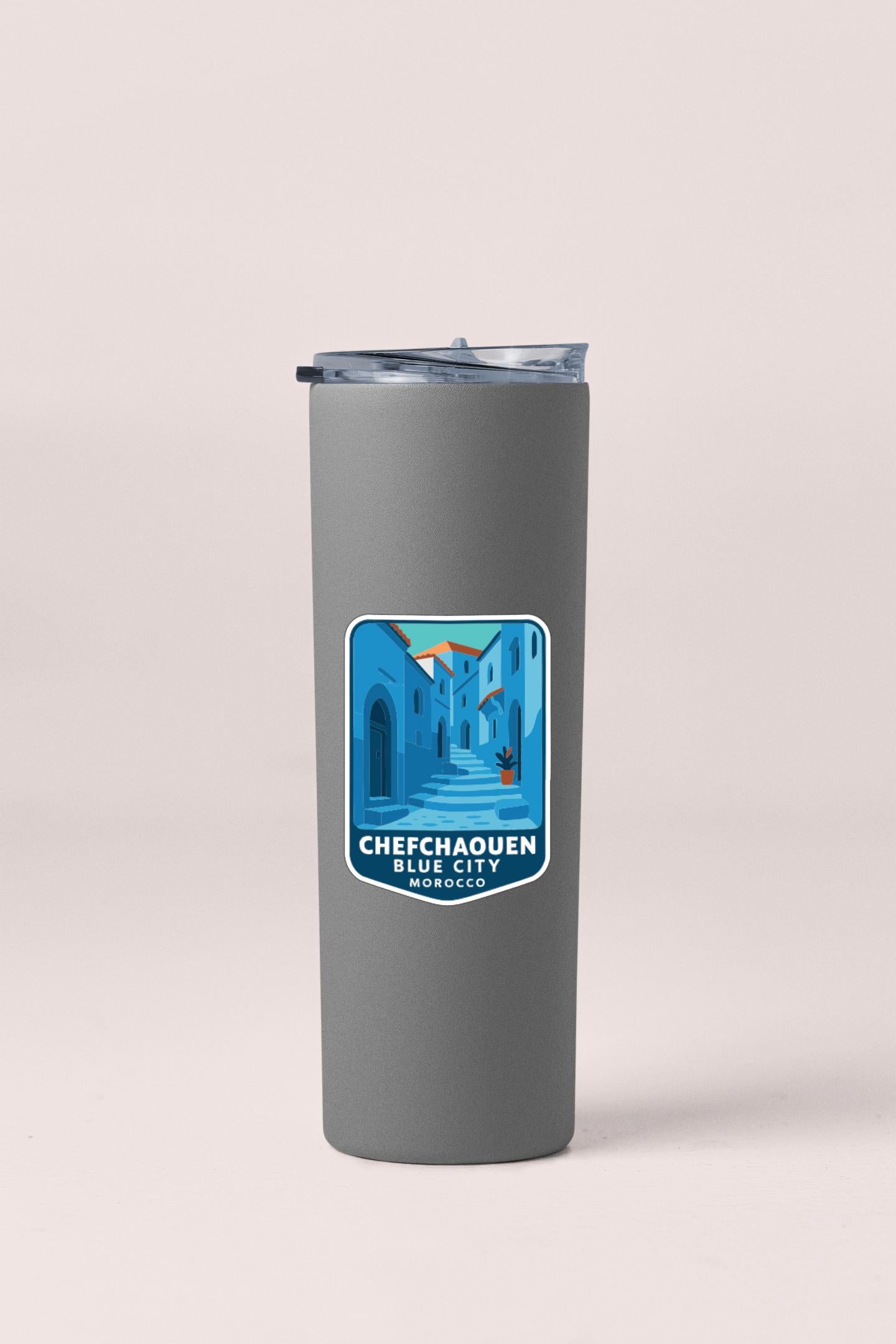 A gray insulated tumbler with a blue and white sticker depicting Chefschaouen, Blue City, Morocco.