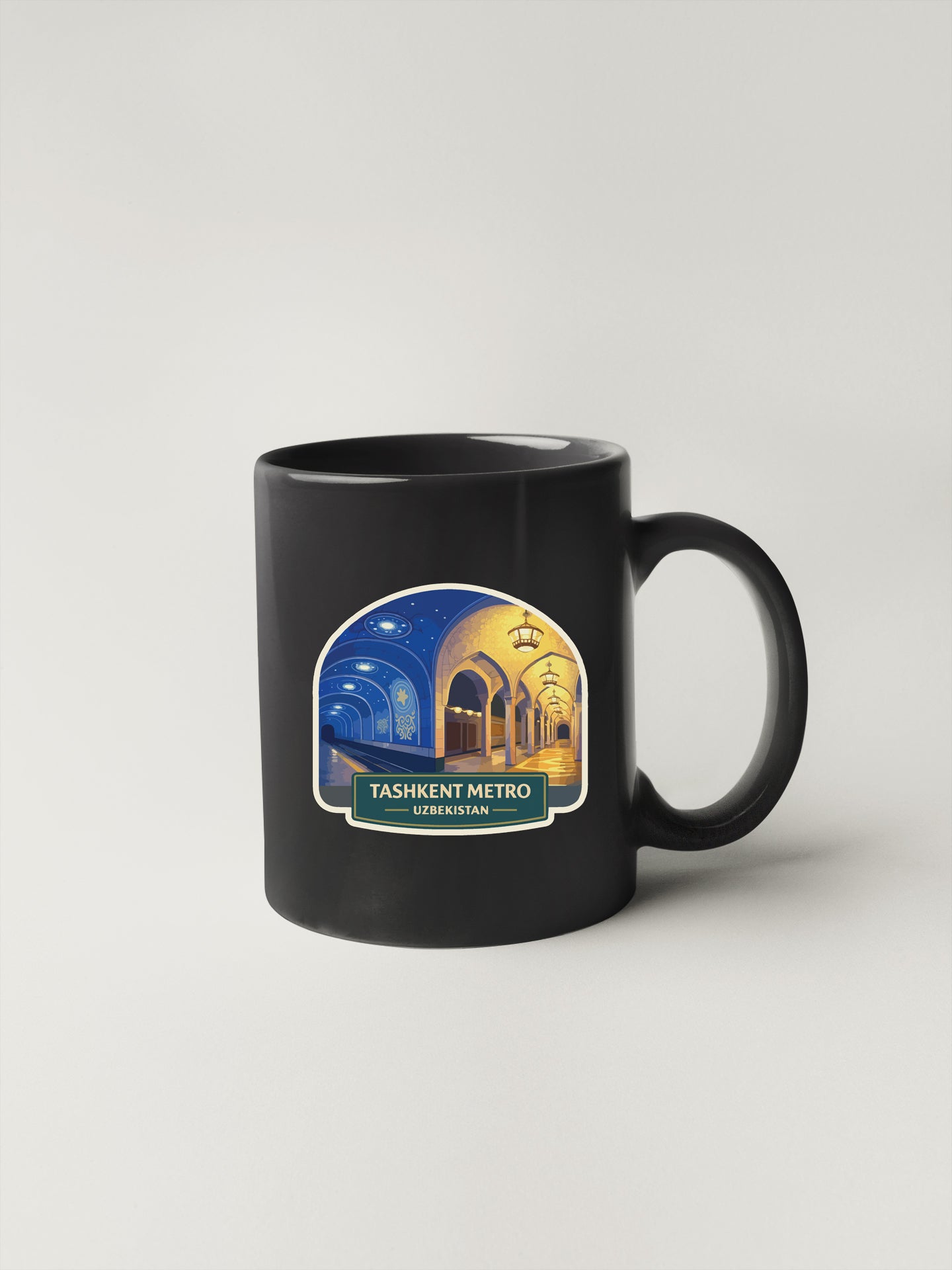 A black coffee mug with a sticker depicting a night scene in Tashkent, Uzbekistan.