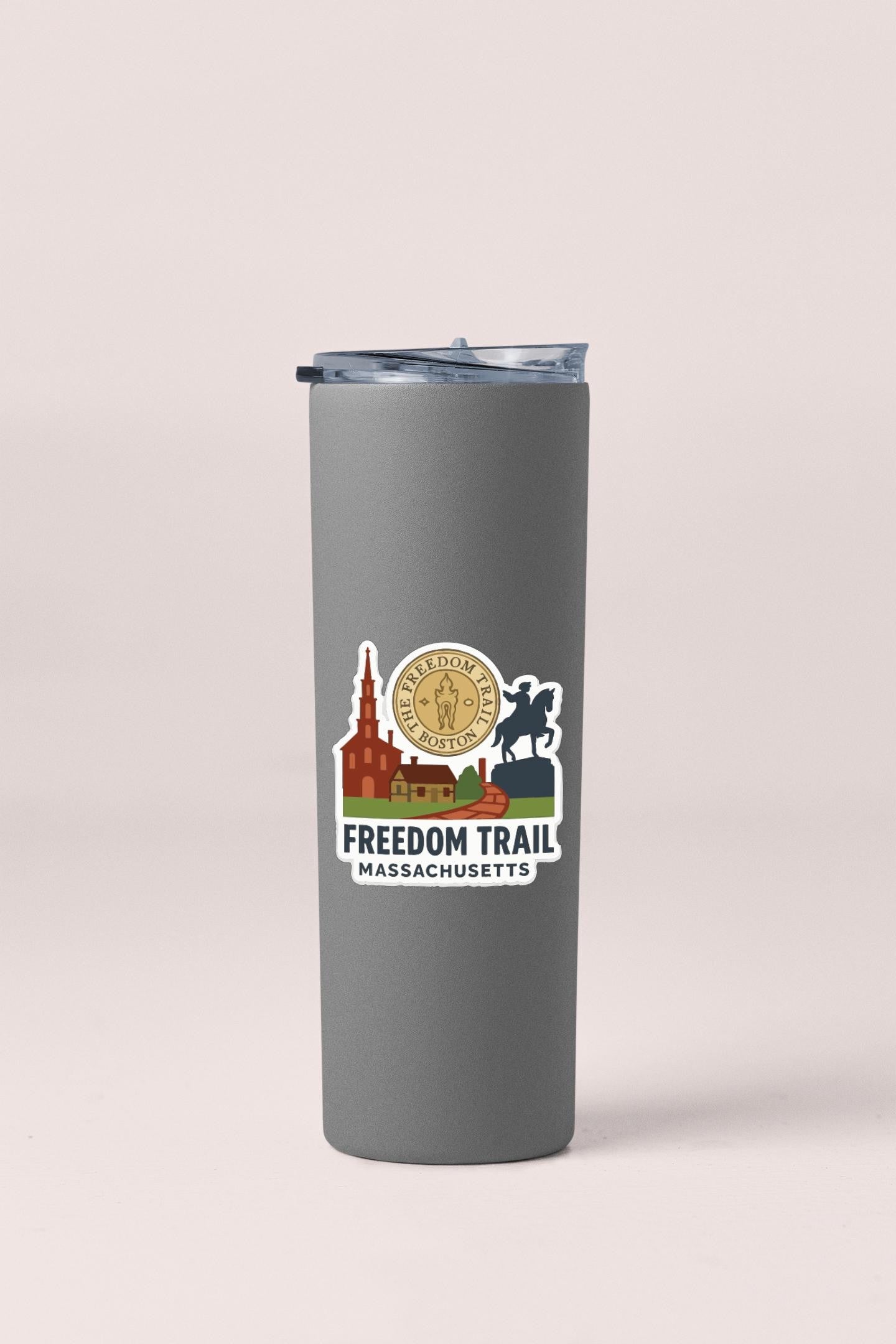 A gray insulated tumbler with a sticker featuring a city skyline and the text "FREEDOM TRAIL MASSACHUSETTS".