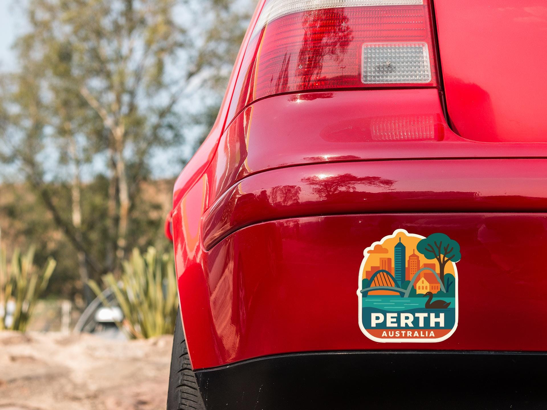 the rear end of a red car with a sticker on the back window that says "Perth Australia".