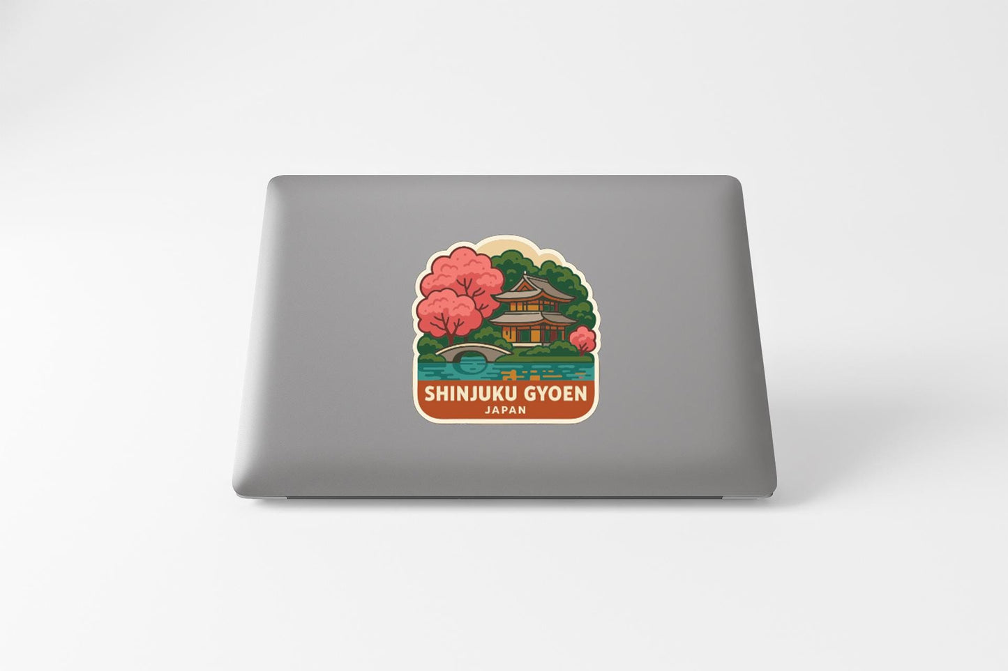 A sticker depicting a traditional Japanese temple surrounded by cherry blossom trees, with the text "SHINJUKU GYOEN JAPAN" below it.