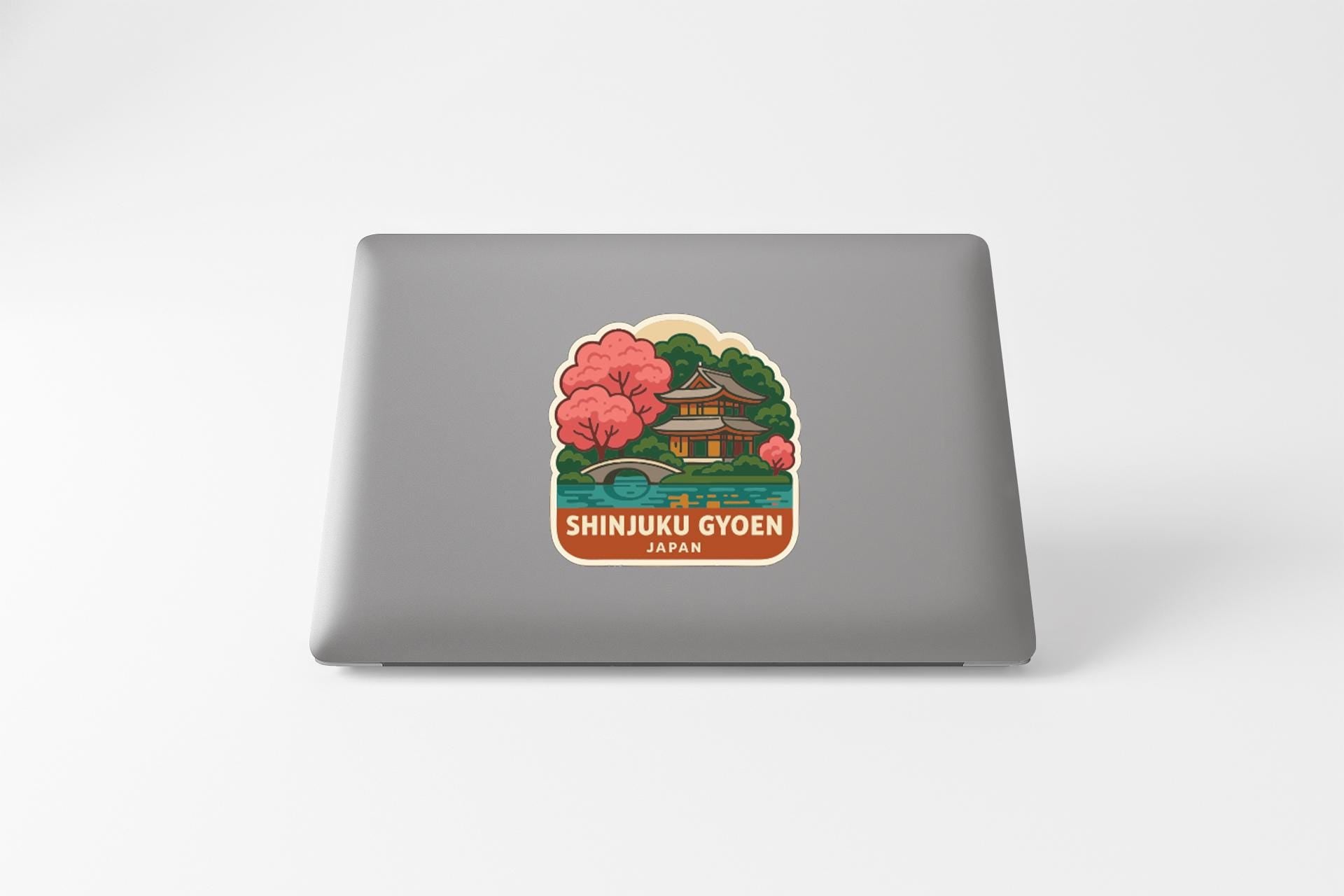 A sticker depicting a traditional Japanese temple surrounded by cherry blossom trees, with the text "SHINJUKU GYOEN JAPAN" below it.