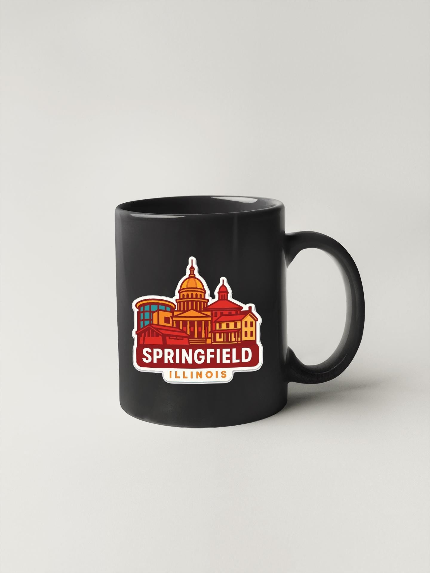A black coffee mug with a colorful graphic of the city of Springfield, Illinois.