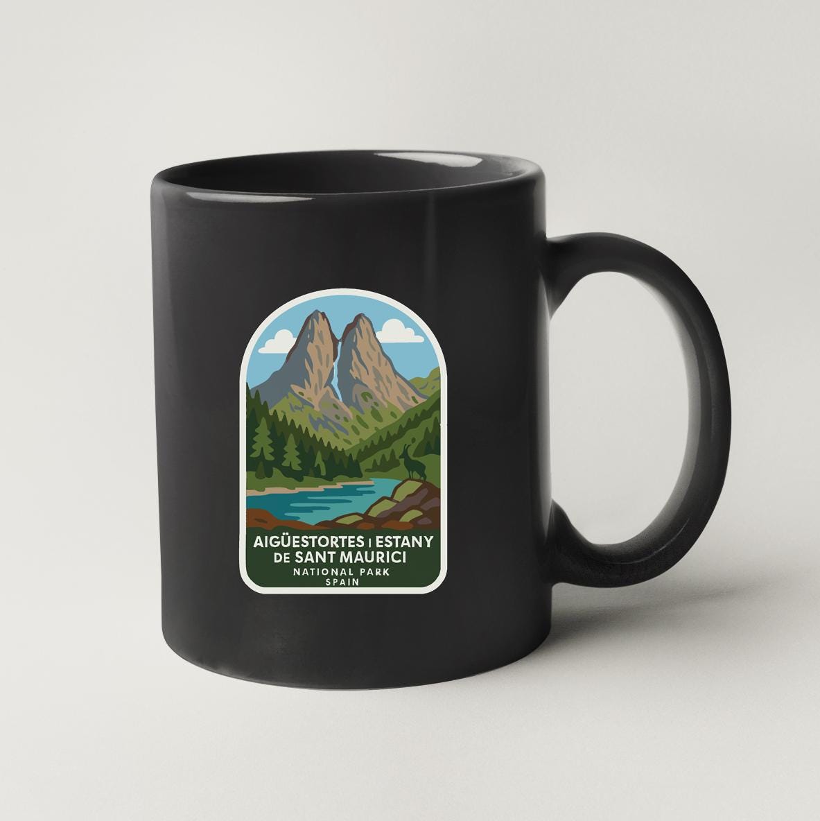 A black coffee mug with a label depicting a mountain landscape and a river.