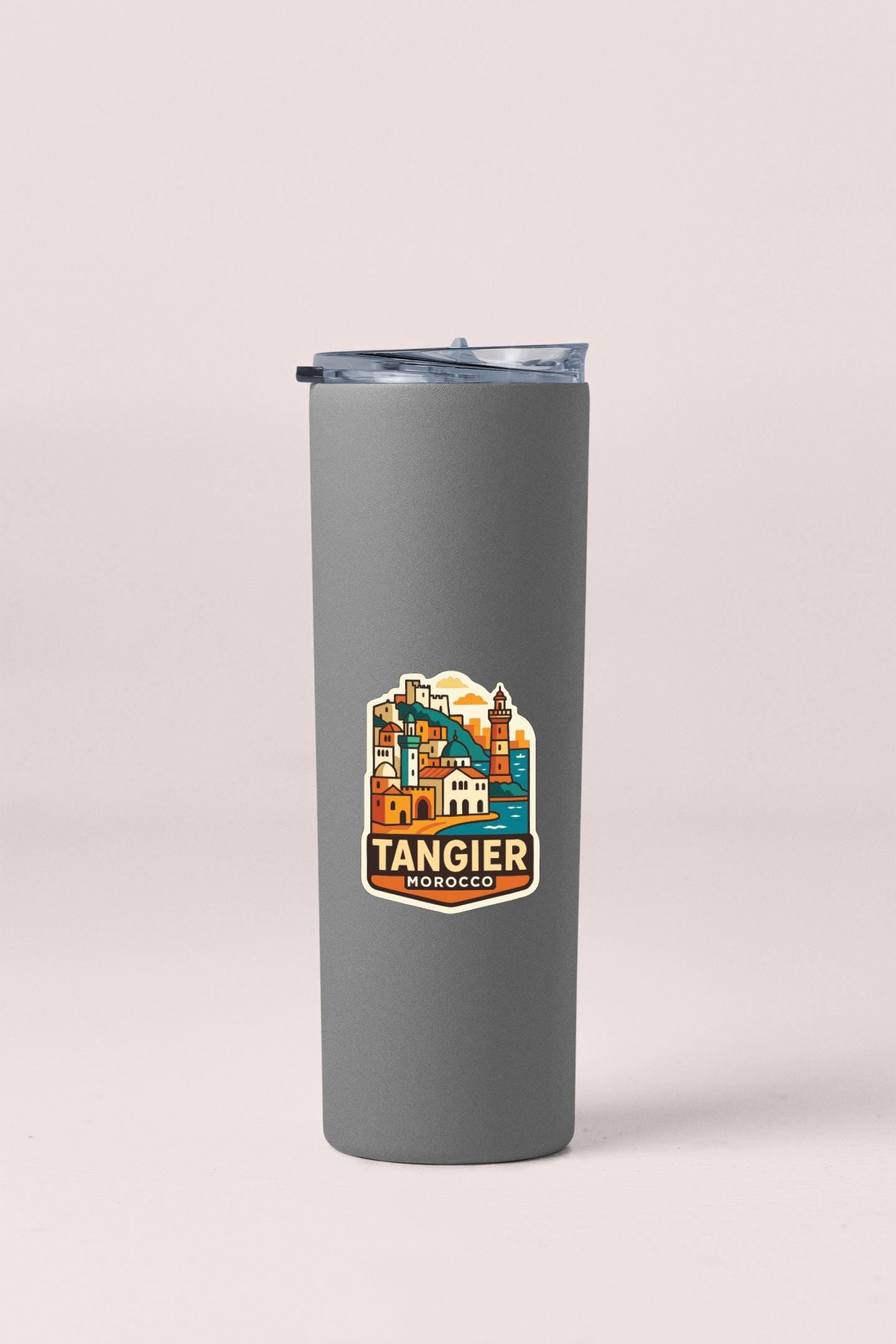A gray insulated tumbler with a sticker depicting the city of Tangier, Morocco.