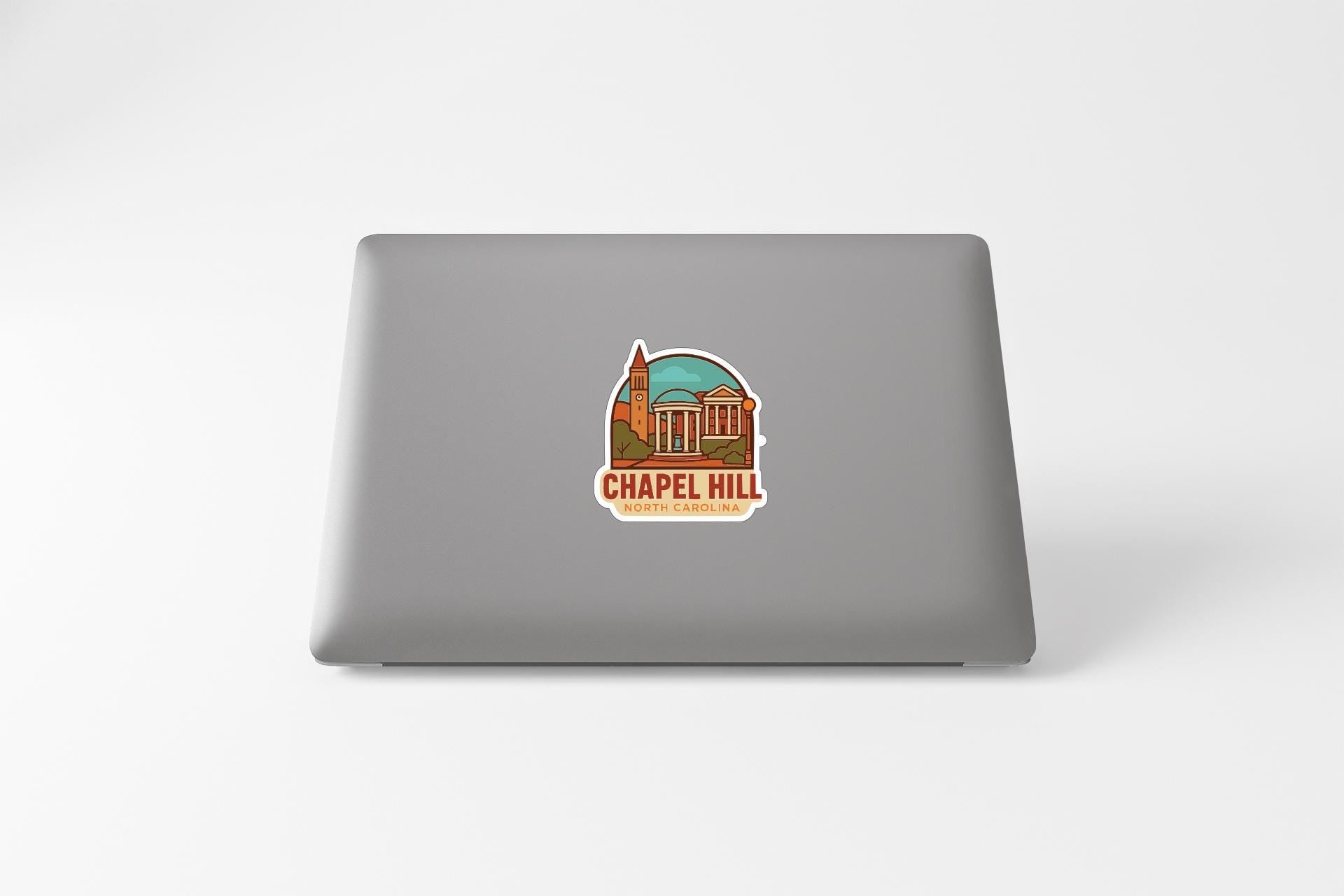 a sticker with an illustration of a building and the text "Chapel Hill" on the back of a laptop.