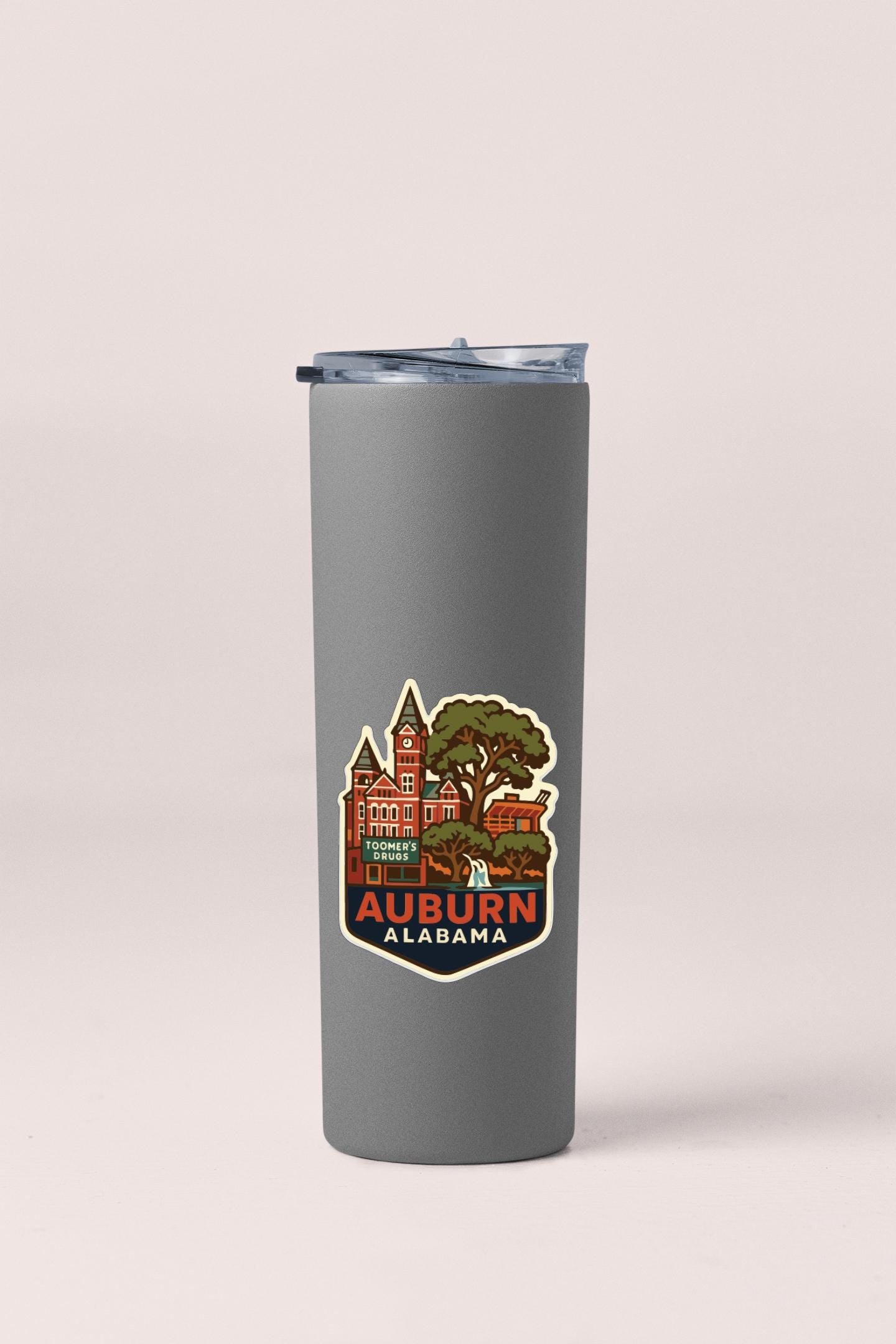 A gray insulated tumbler with a printed design of a cityscape and the text "Auburn Alabama" on it.