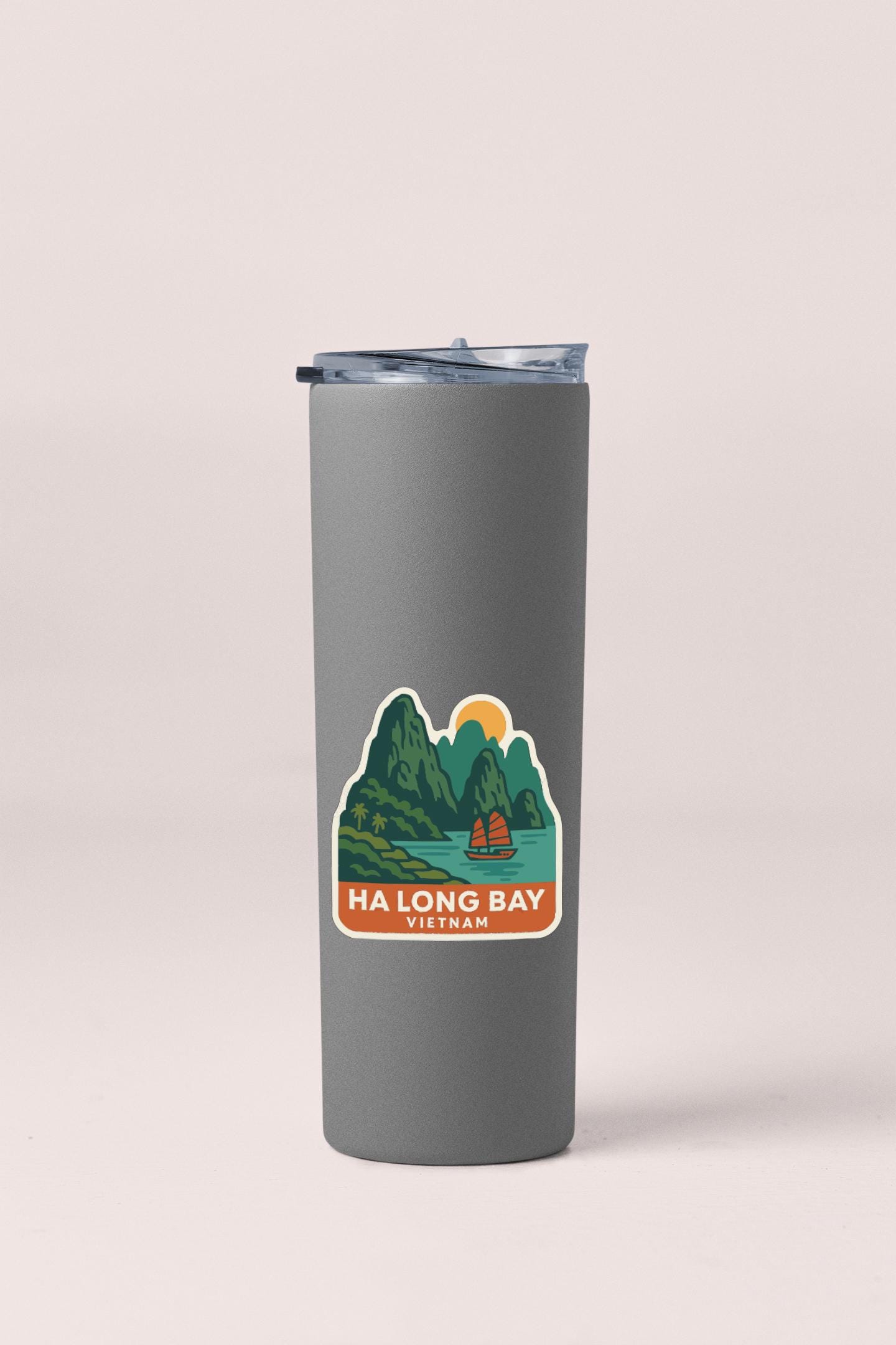 A gray insulated tumbler with a sticker depicting Ha Long Bay in Vietnam.