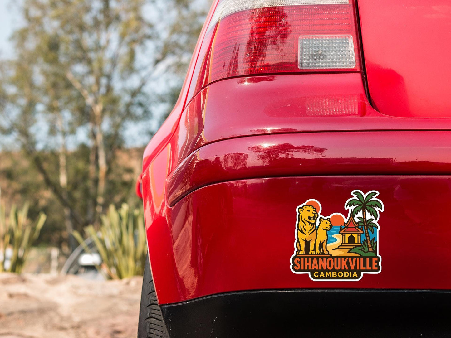 the rear end of a red car with a sticker on the trunk that says "Sihanoukville Cambodia".