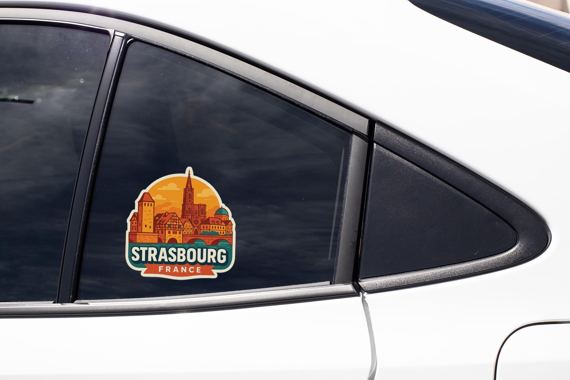 A sticker on the side of a car window, depicting the city of Strasbourg, France.
