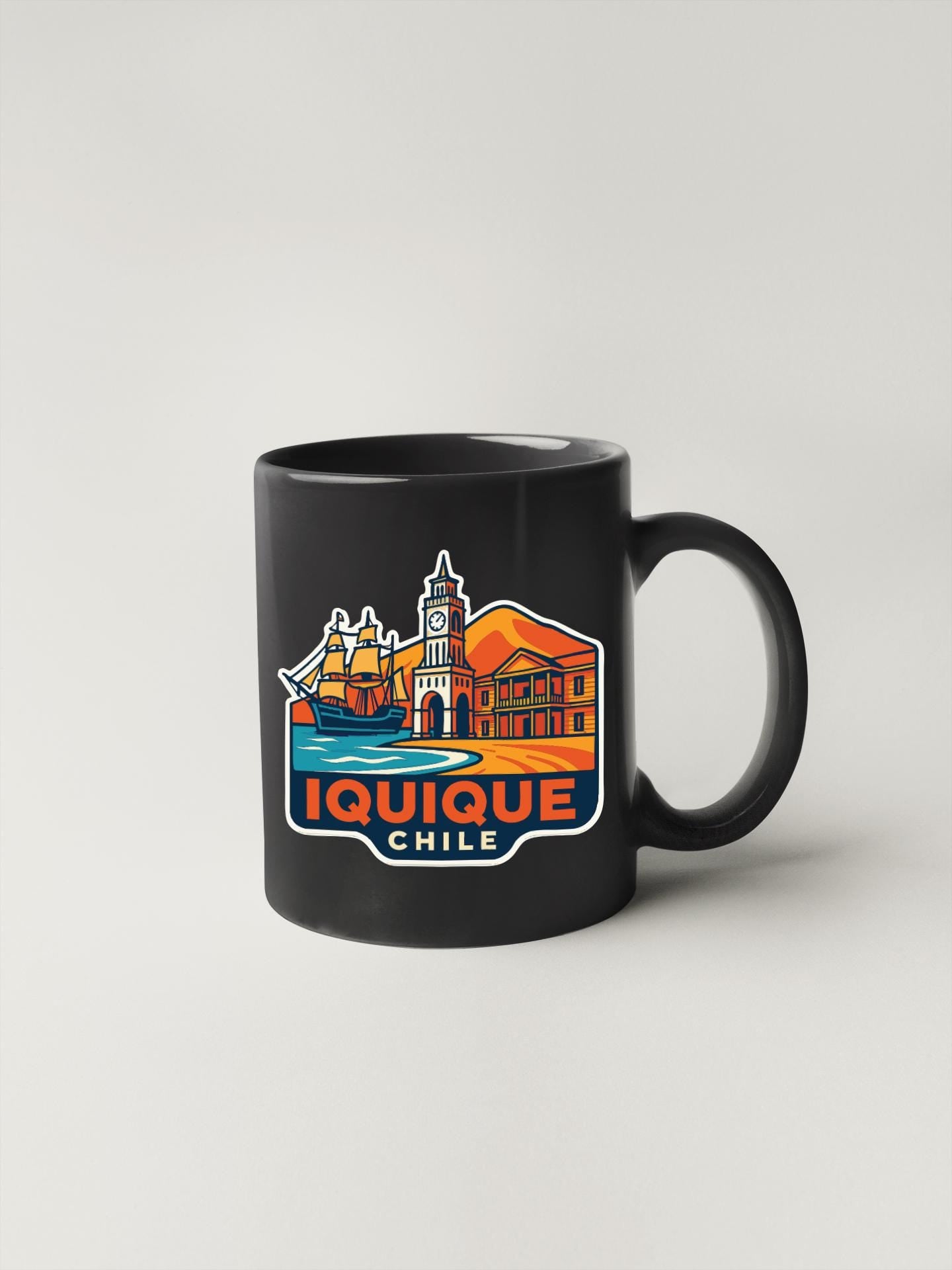 A black coffee mug with a colorful illustration of a cityscape and the text "IQUIQUE CHILE" printed on it.