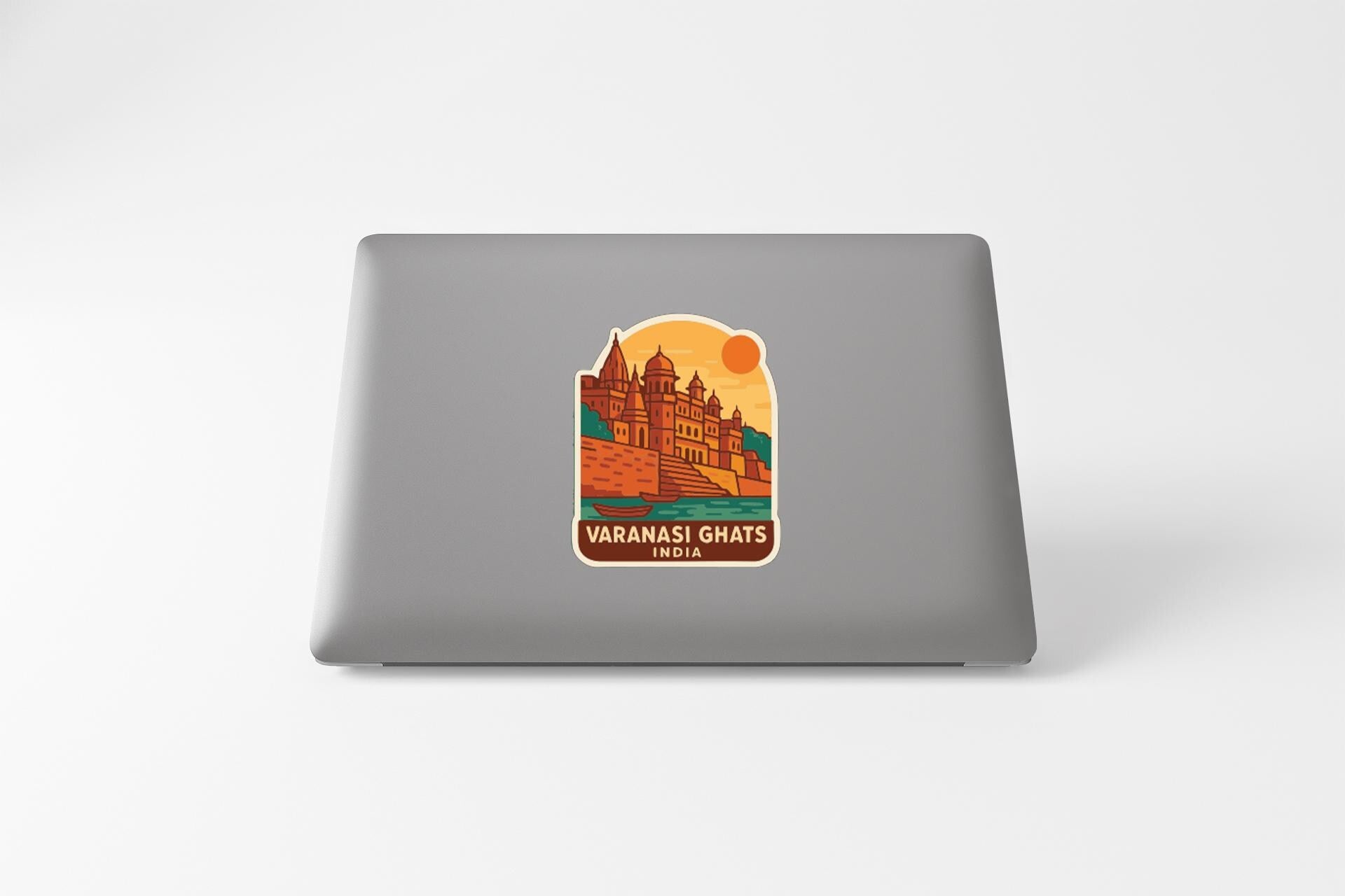 A sticker on the back of a laptop, depicting a castle or palace with a sun in the background.