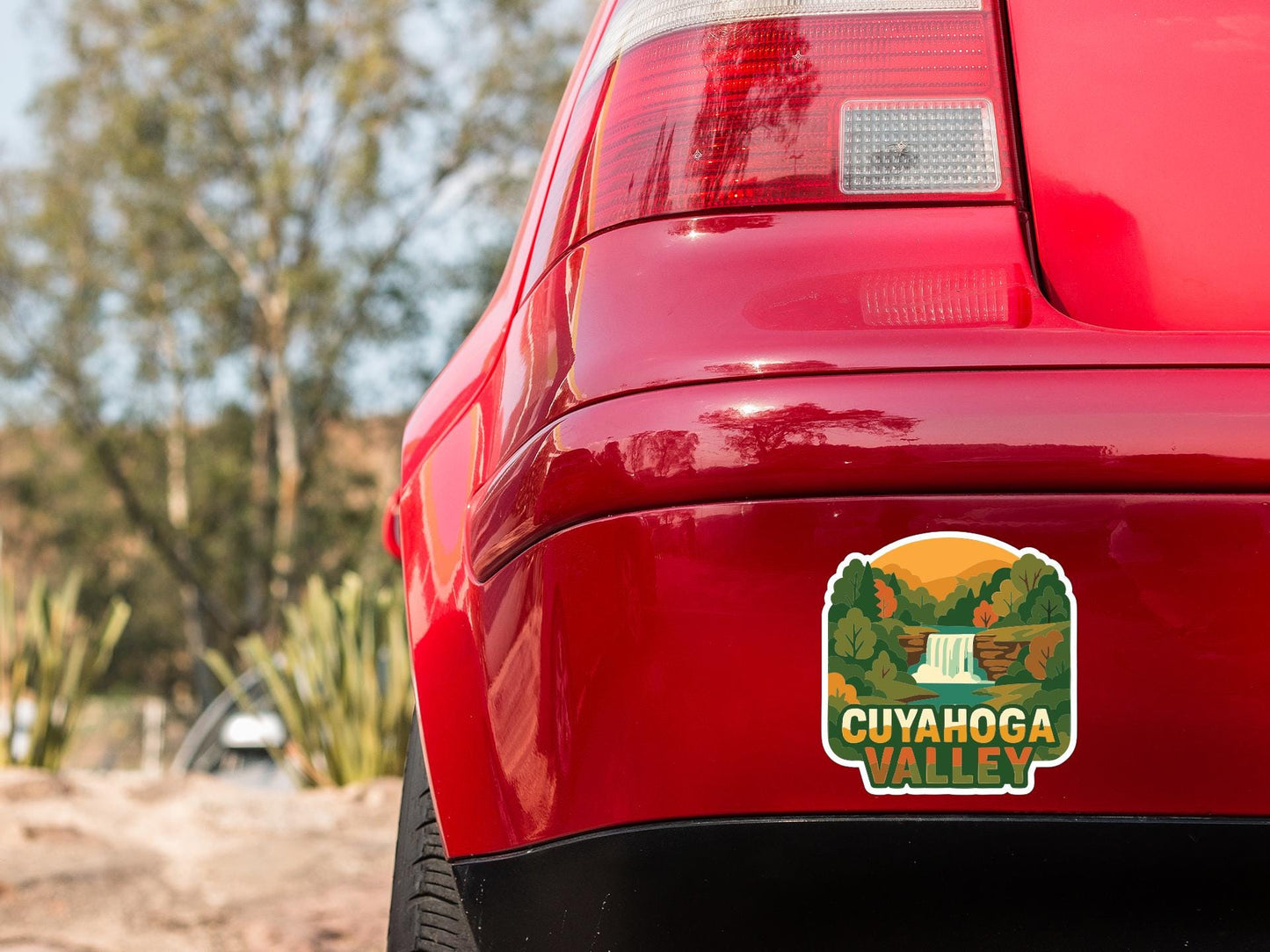 the rear end of a red car with a sticker on the back window that says "Cuyahoga Valley".