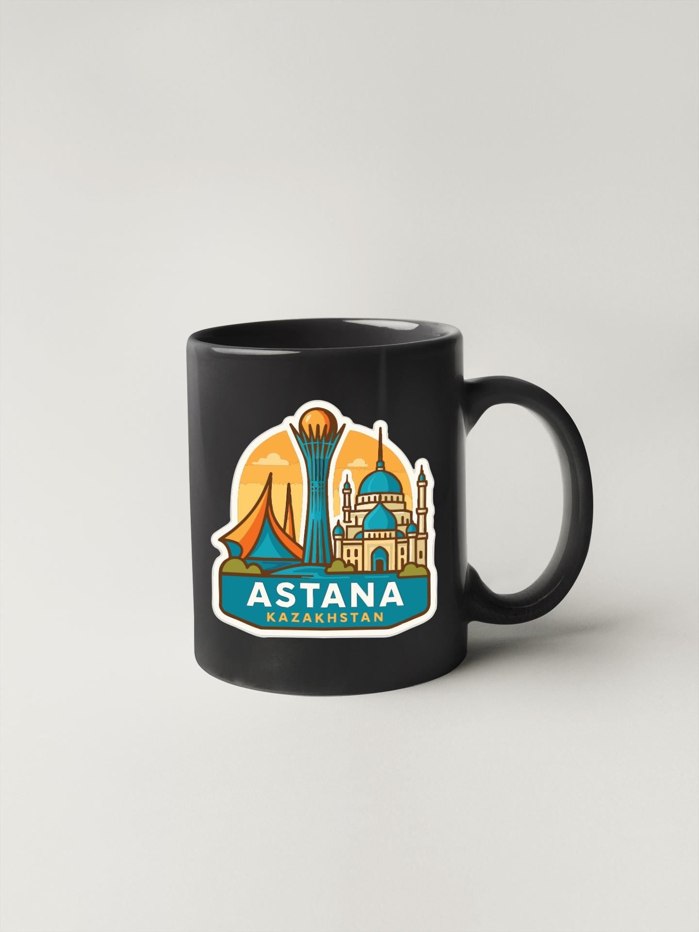 A black coffee mug with a sticker depicting the skyline of Astana, the capital city of Georgia.