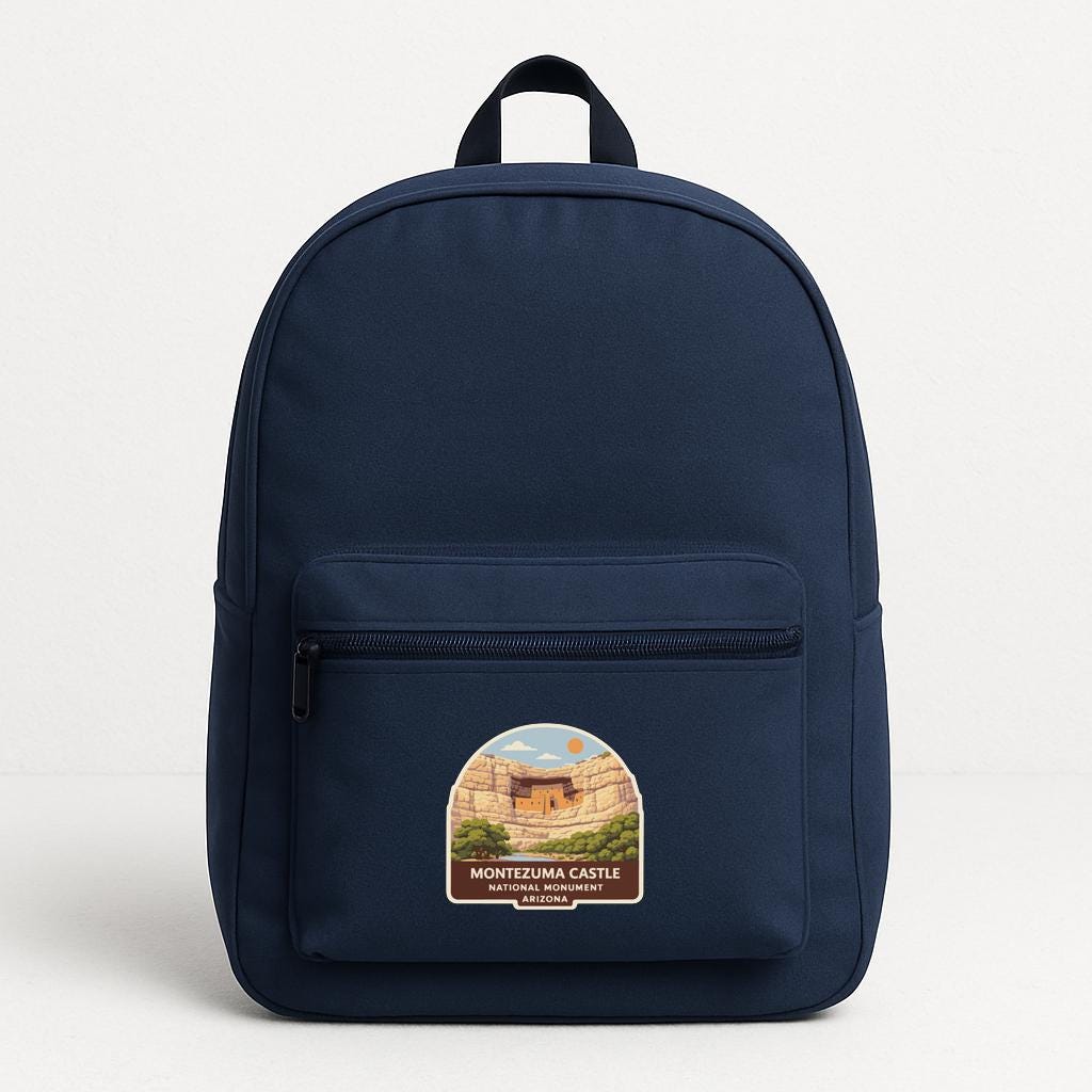 A navy blue backpack with a label that says "MONTEZUMA CASTLE NATIONAL PARK ARIZONA".