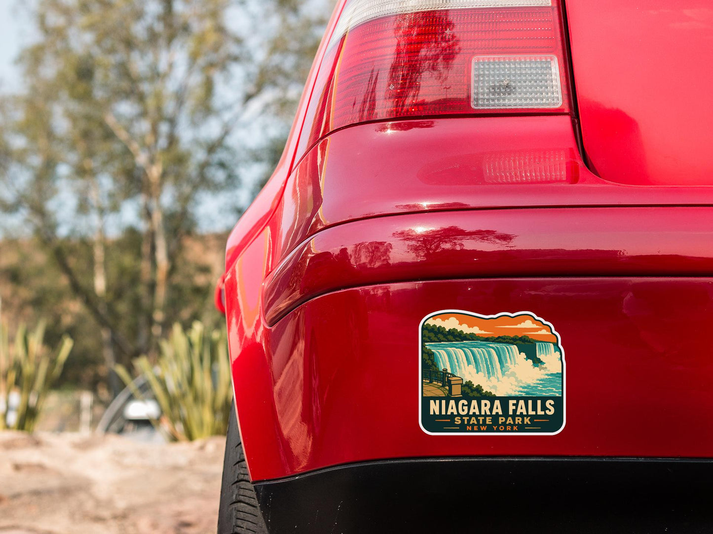 the rear end of a red car with a sticker on the trunk that says " Niagara Falls State Park".