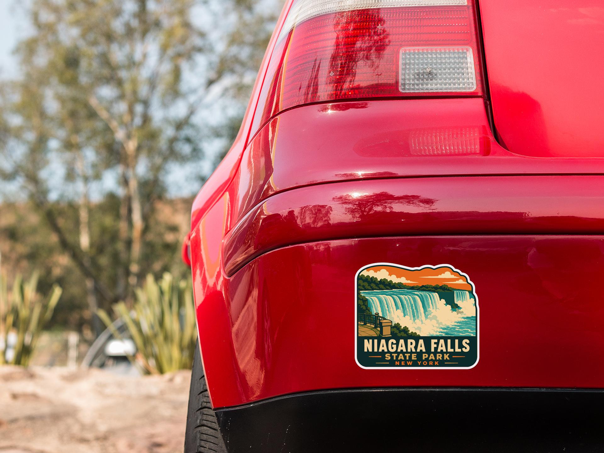 the rear end of a red car with a sticker on the trunk that says " Niagara Falls State Park".