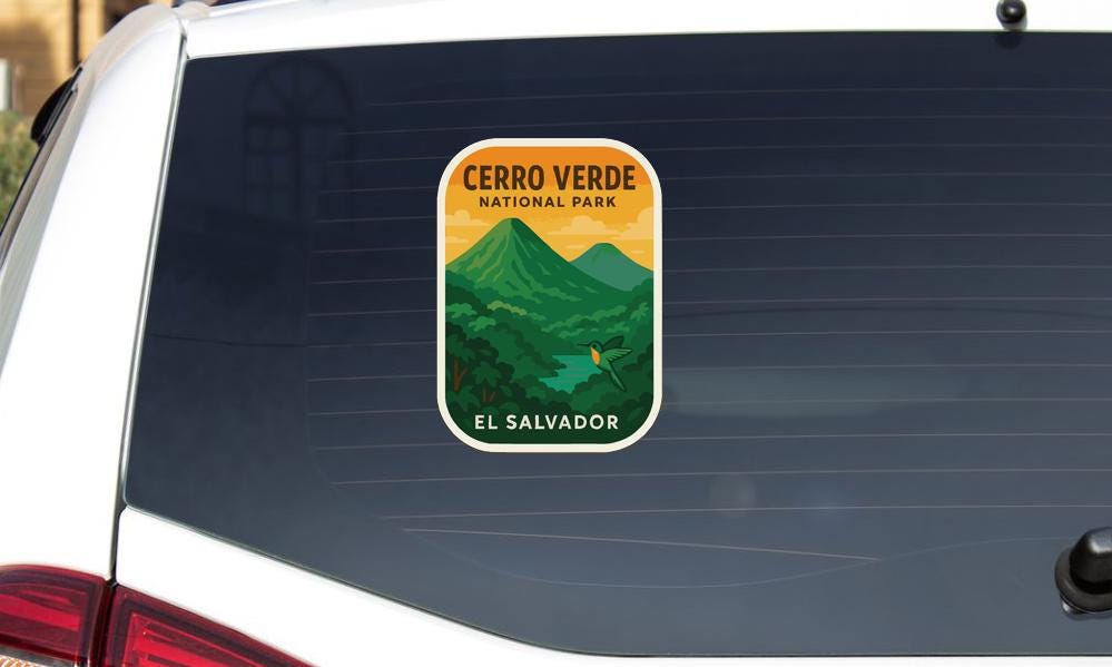 A sticker on the rear window of a vehicle, depicting a scenic landscape with mountains and a river, representing Cerro Verde National Park in El Salvador.