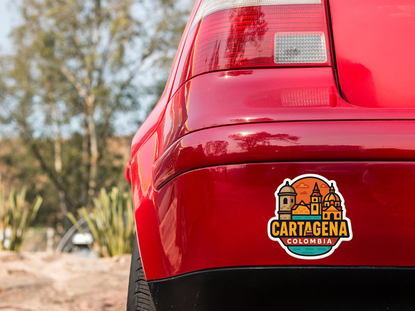 the rear end of a red car with a sticker on the trunk that says "Cartagena Colombia".