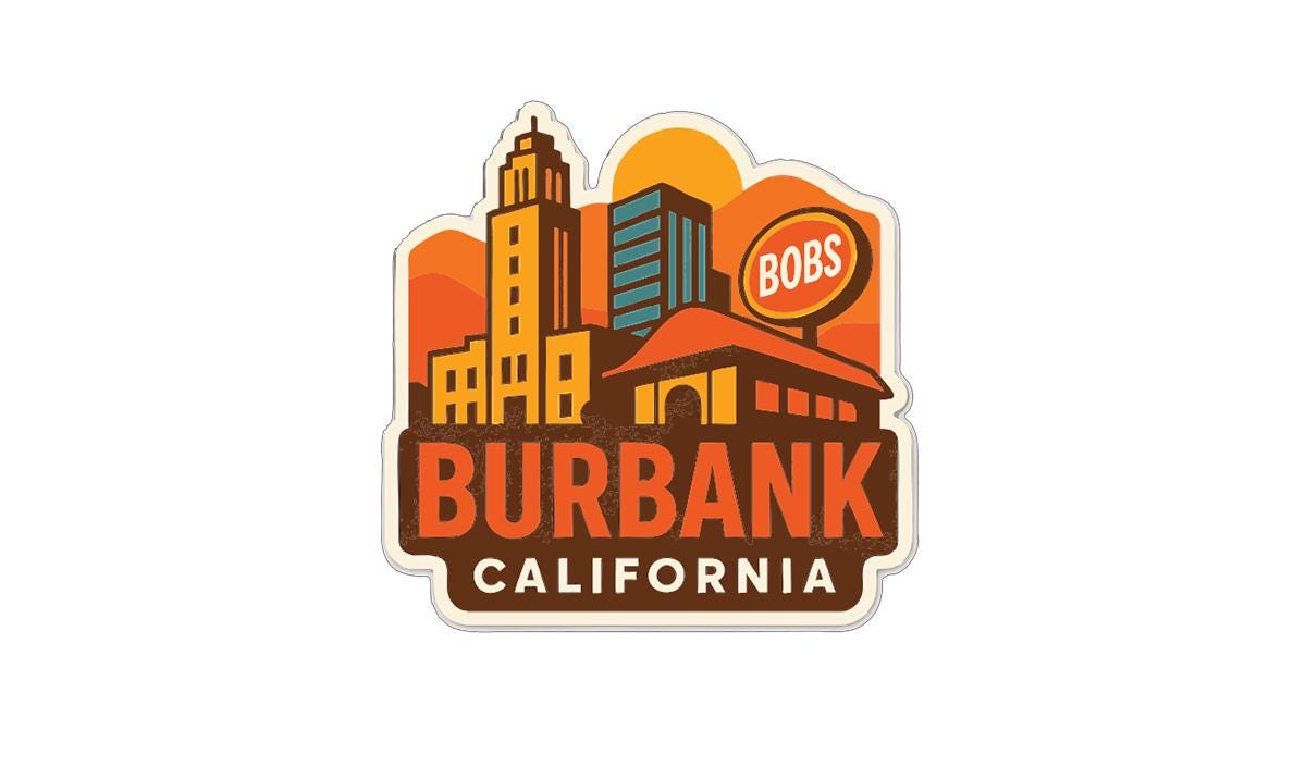 a sticker or emblem with a stylized illustration of a city skyline, including a prominent building with the name "Bobs" written on it.