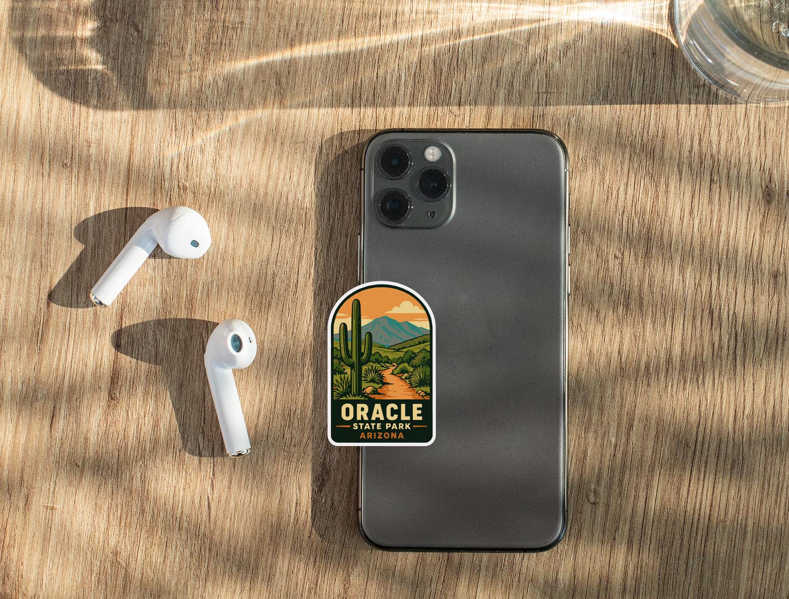 a smartphone with a sticker on it, along with a pair of white earbuds and a glass of water on a wooden surface.