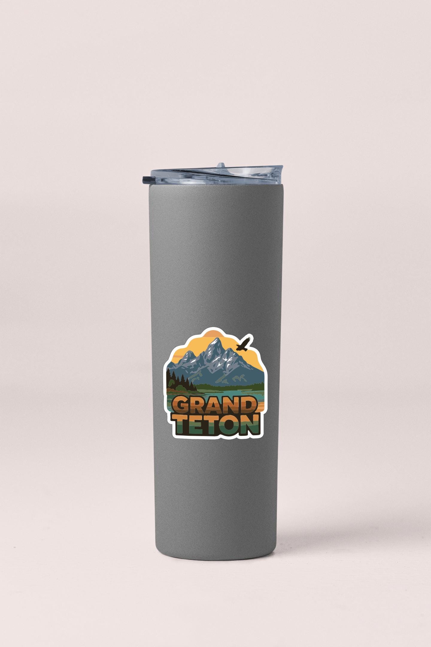A gray insulated tumbler with a printed logo that says "GRAND Teton".