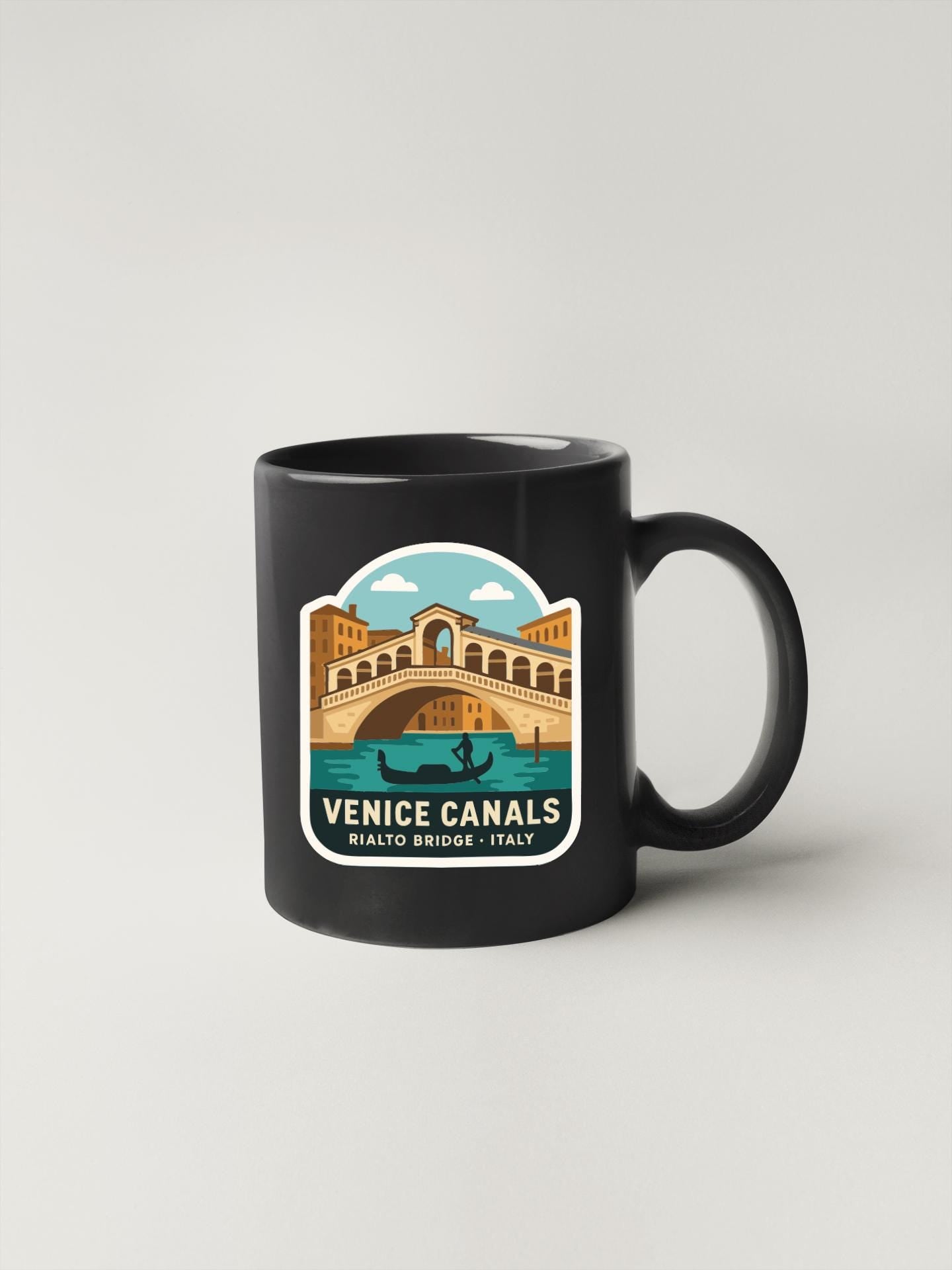 A black coffee mug with a graphic design depicting the Rialto Bridge and the Venice canals.