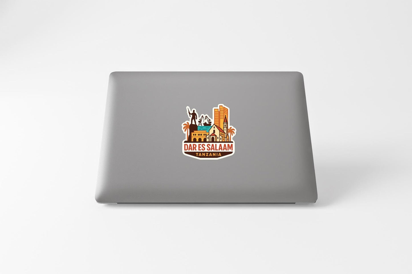 a sticker on the back of a laptop, depicting a cityscape with various buildings and landmarks.
