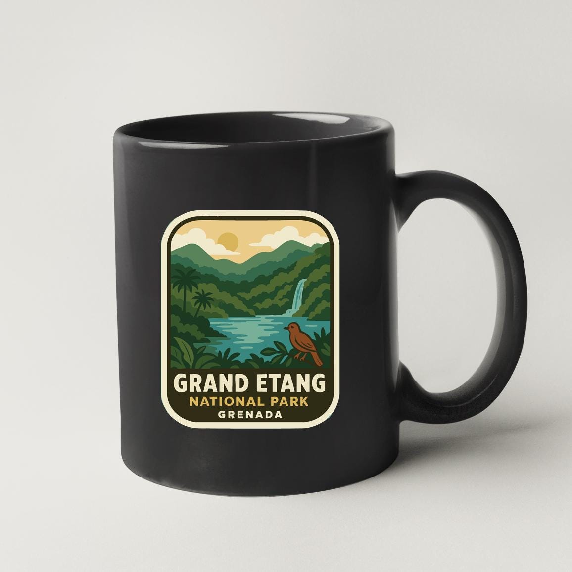 A black coffee mug with a label that says "GRAND ETANG NATIONAL PARK GRENADA".