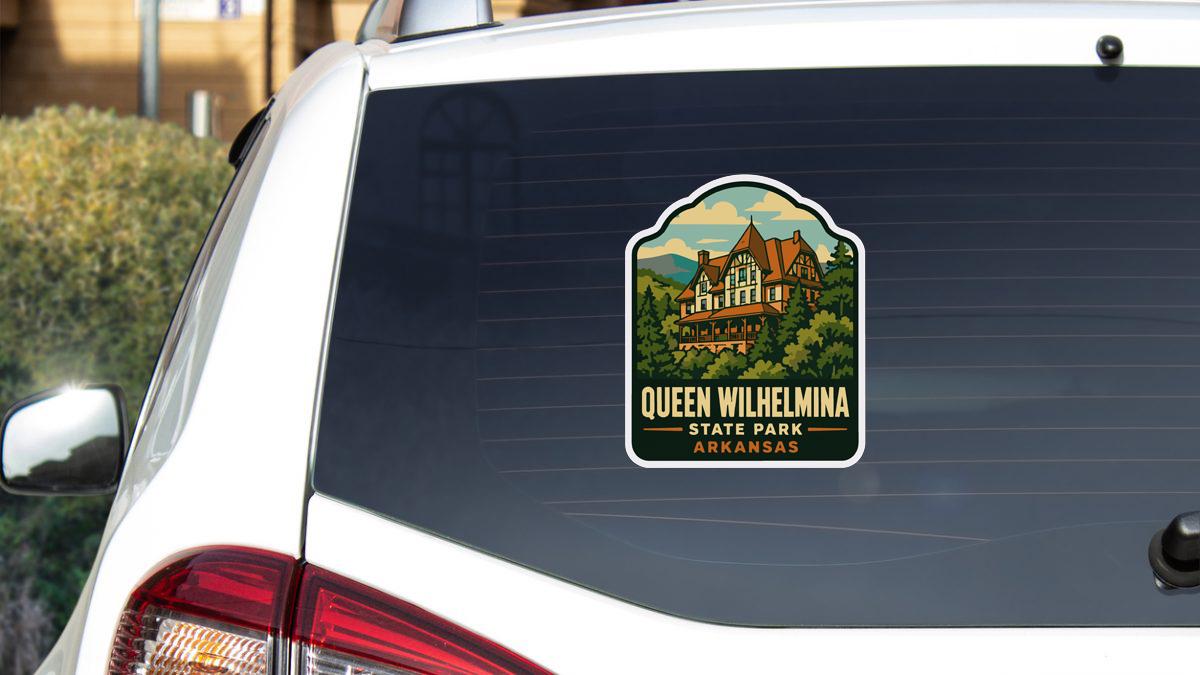 A sticker on the rear window of a white car, depicting a scenic image of Queen Wilhelmina State Park in Arkansas.