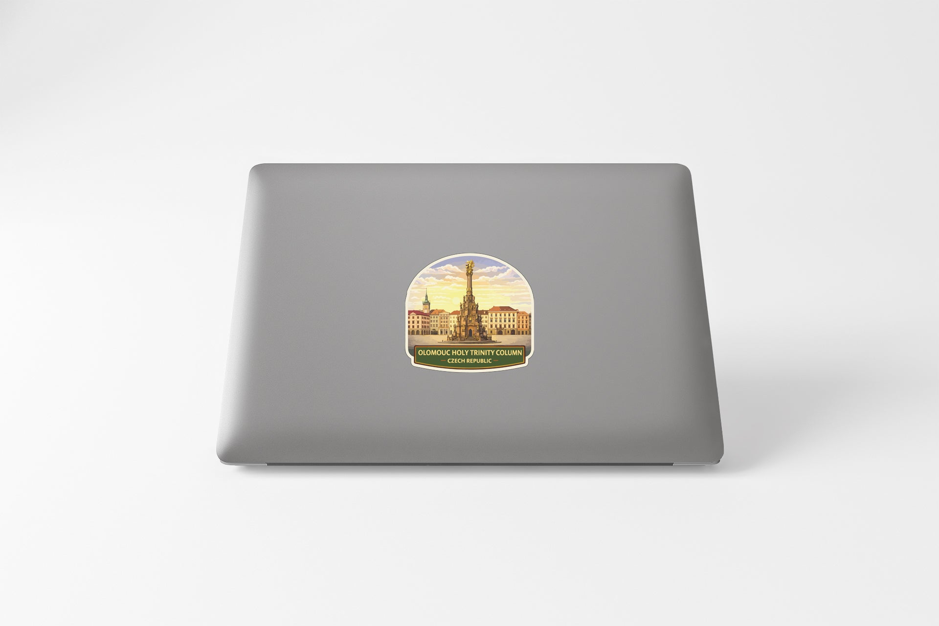 a sticker on the back of a laptop, depicting a cityscape with a tall tower in the center.