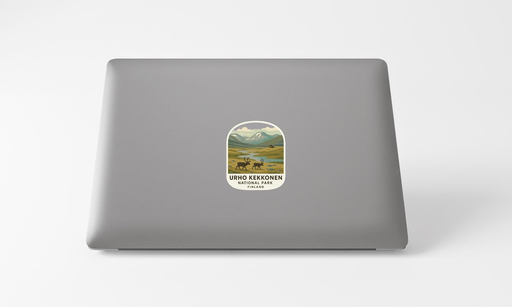A sticker on the back of a laptop, depicting a scenic landscape with mountains, a river, and wildlife.