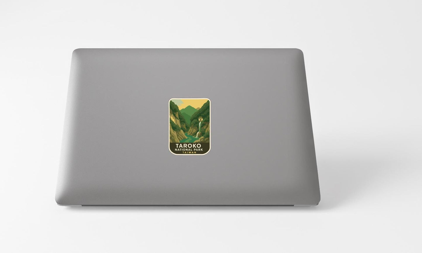 A sticker with a mountain landscape on a laptop.