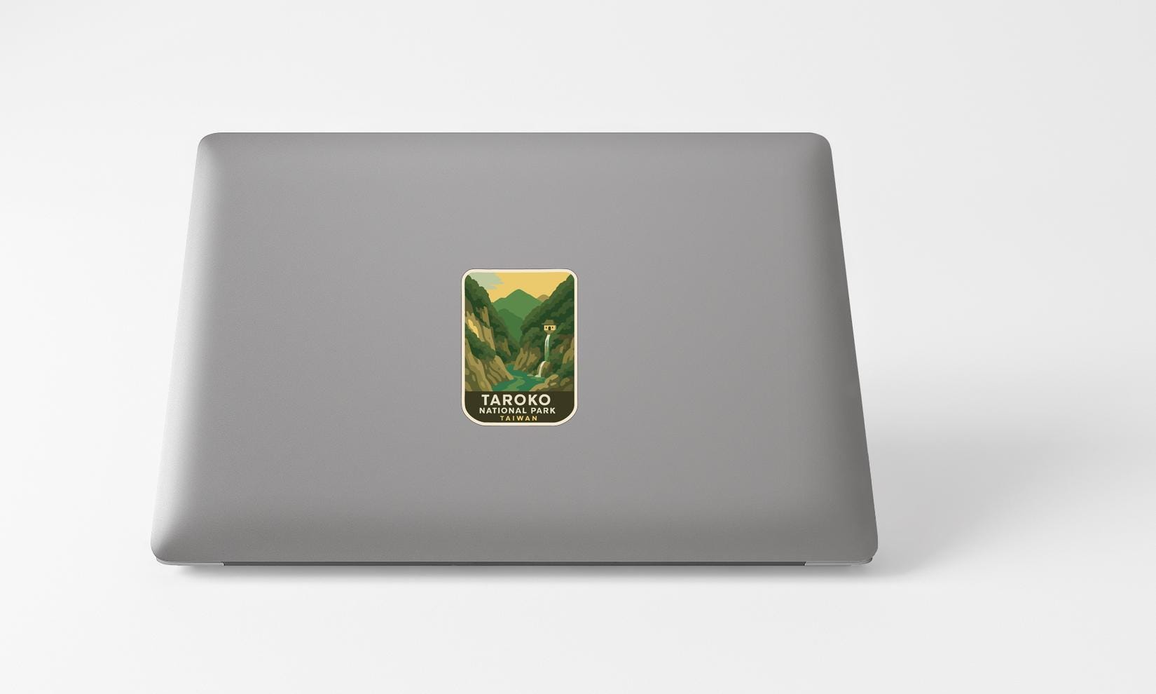 A sticker with a mountain landscape on a laptop.