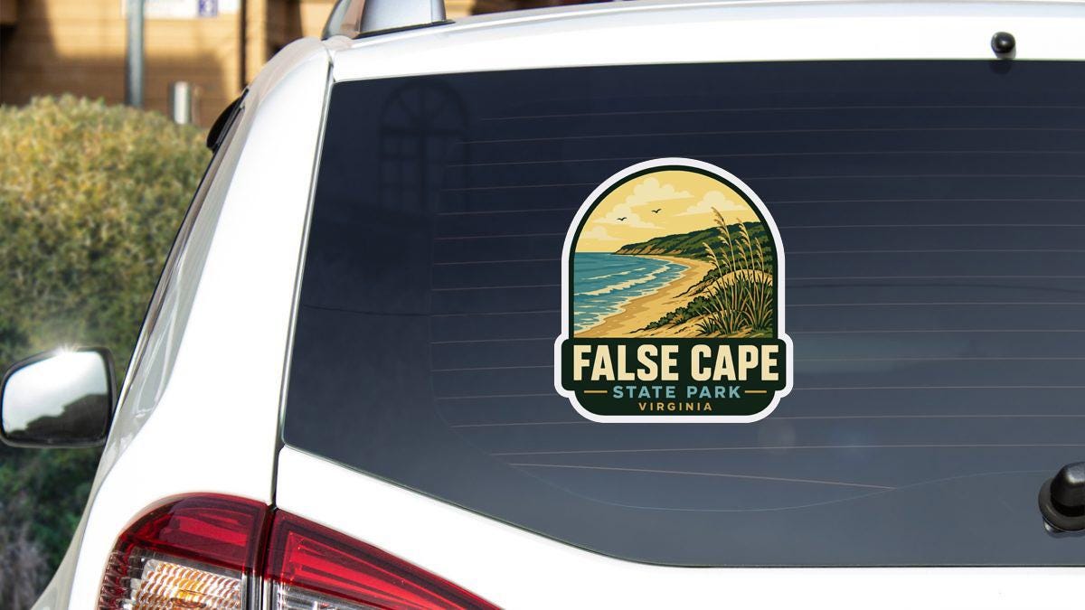 A sticker on the rear window of a white car that says "FALSE CAPE STATE PARK VIRGINIA".