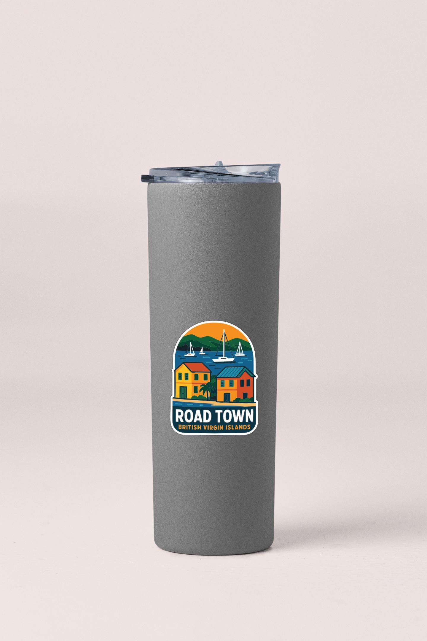 A gray insulated tumbler with a logo depicting a coastal town scene.